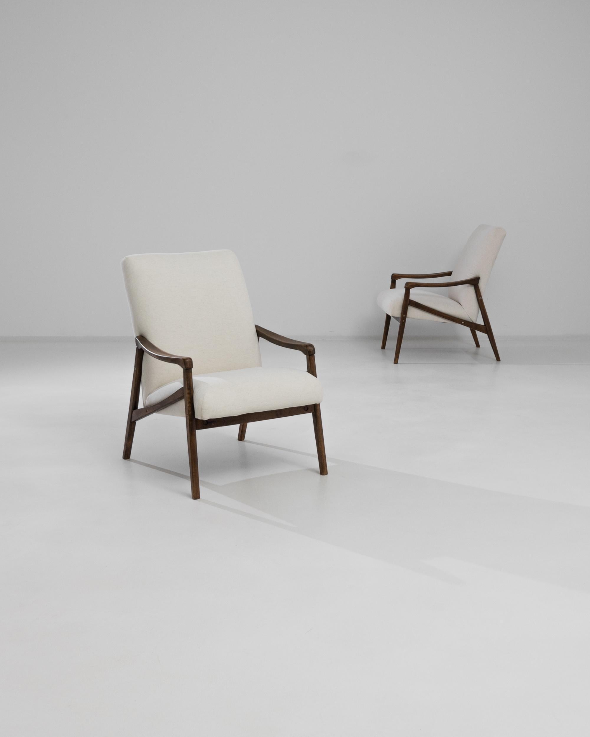 Cette paire de fauteuils de style moderne du milieu du siècle combine sans effort simplicité et sophistication. Fabriqué dans l'ancienne Tchécoslovaquie dans les années 1960, le design est attribué à Jiri Jiroutek. La courbe douce des accoudoirs en