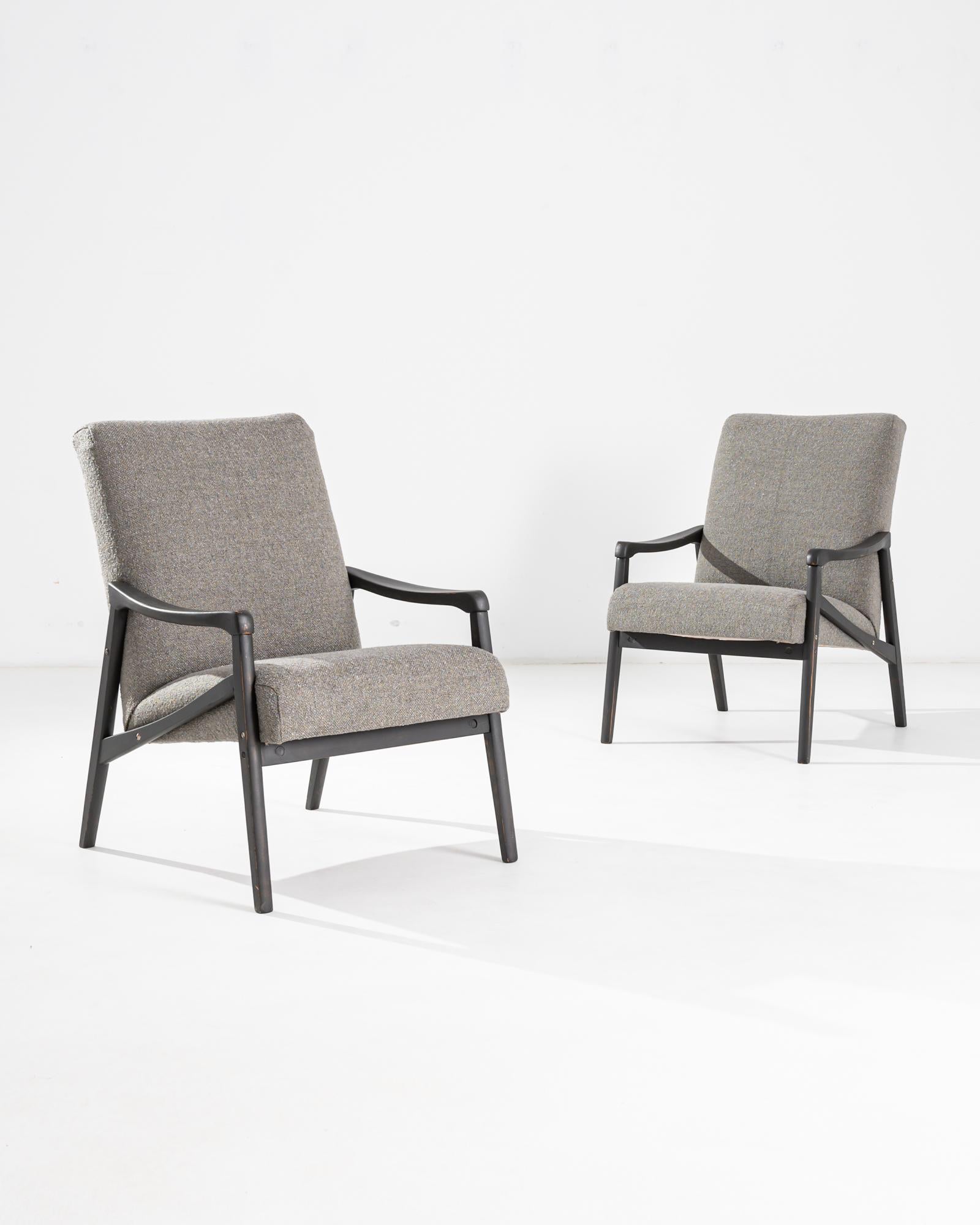A pair of armchairs produced in the former Czechoslovakia, with the design attributed to Jiri Jiroutek. This 1960s design is re-upholstered in an updated taupe bouclé upholstery; the neutral tone was chosen to compliment the polished patina of the