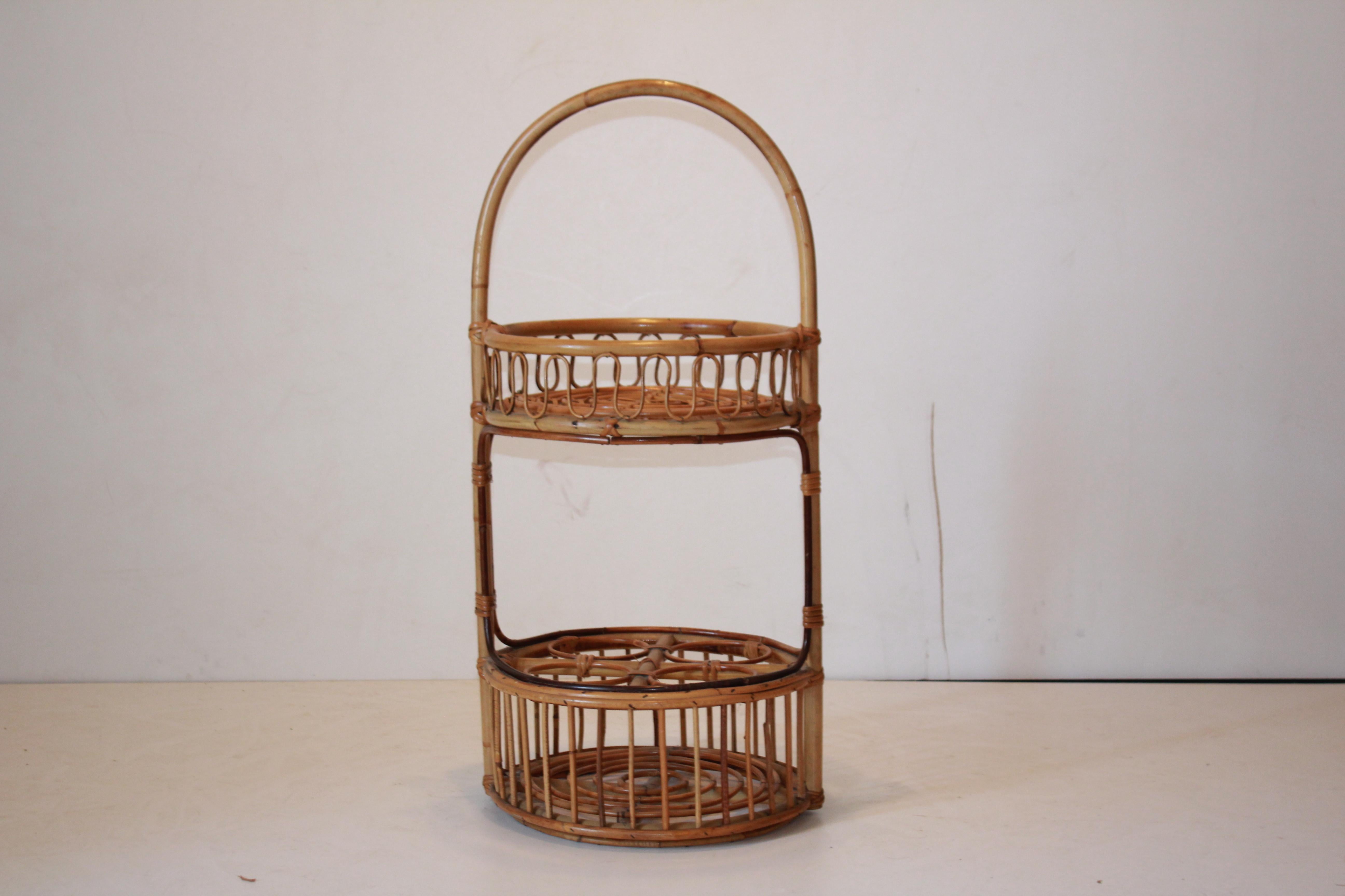 A cosy vintage bamboo drink cocktail side cart produced in Italy in the 1960's.
Circular shape with a confortable curved bamboo handler on the top. Two shelves with the inferior one having four bottles case. In really good conditions with only few