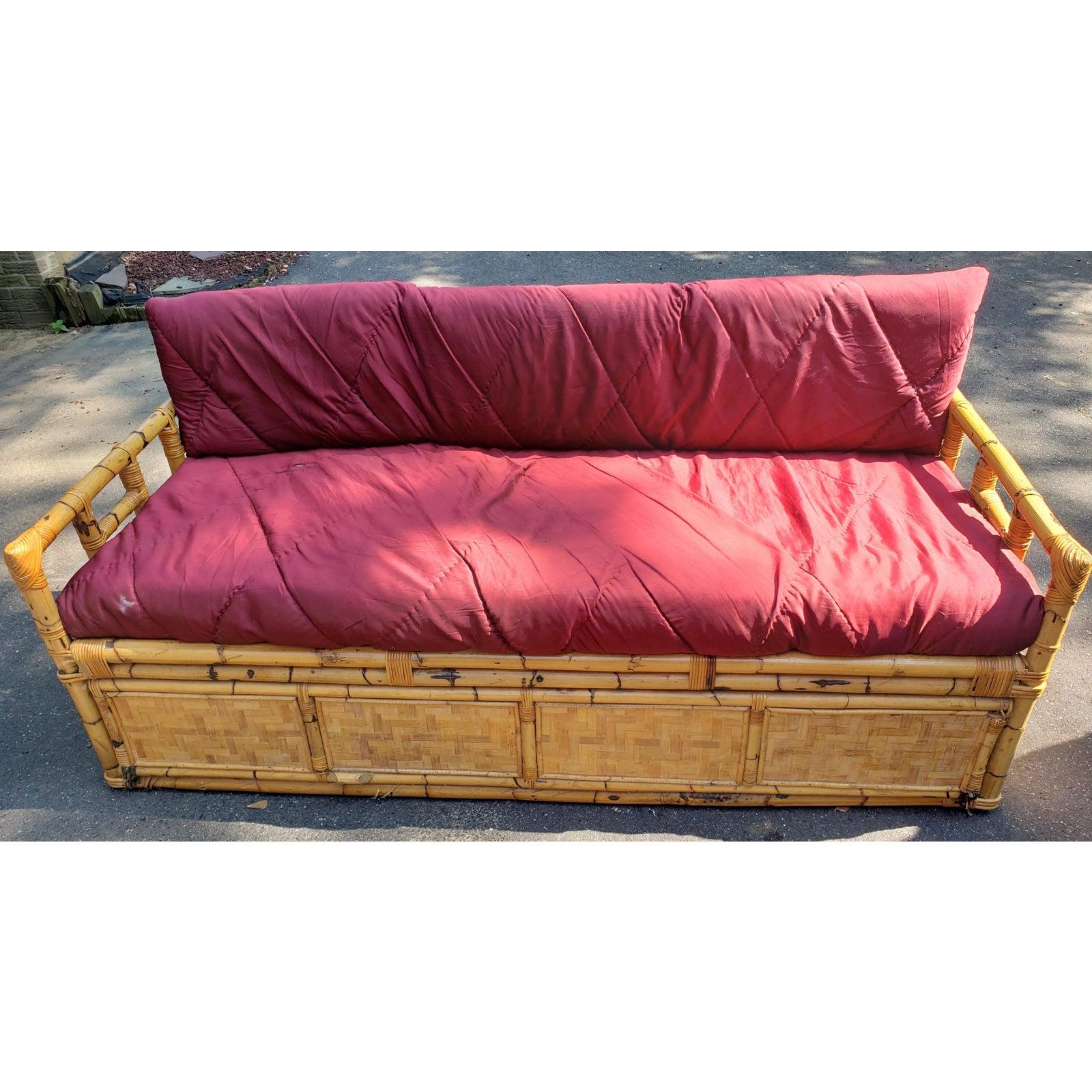 1960s vintage jumbo bamboo Sofa with gated underneath storage. Two large seat and back cushions in polyester with wear consistent with age and use, but no tear. Front lifts up as a gate for large storage area underneath. 
Measurements are: 78.5