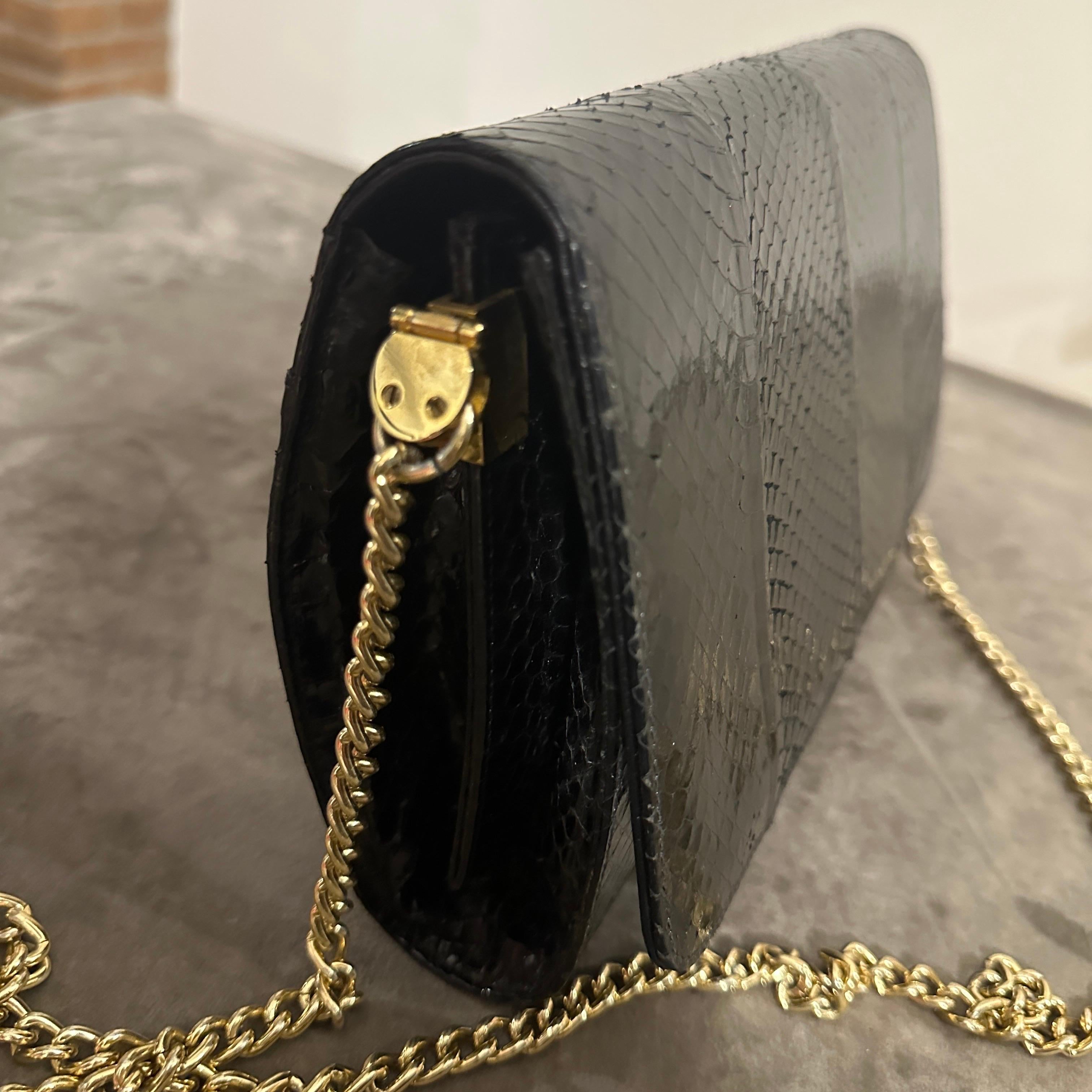 This vintage black leather Italian shoulder bag from the Sixties is a timeless masterpiece, reflecting the understated elegance of mid-century fashion. Crafted from luxurious black leather with a sleek snakeskin pattern, the bag exudes