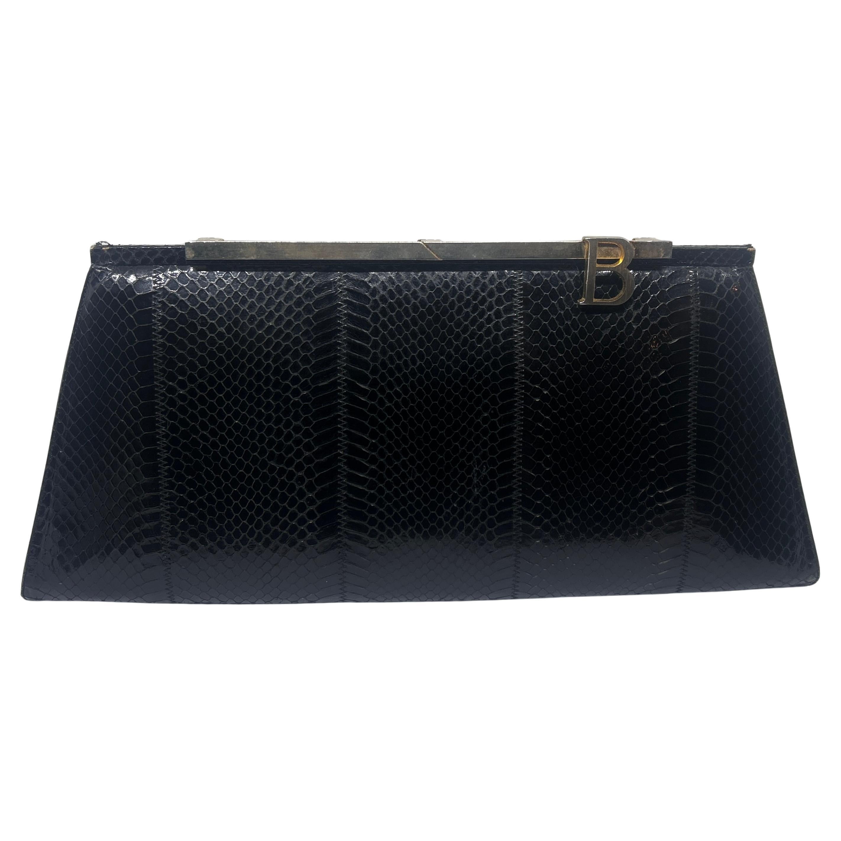 The design is classic and elegant, featuring a gold chain strap and a rectangular shape. The texture of the bag reflects the distinctive patterns of black leather adding to its luxurious appearance. The bag is finished with a gold metal frame at the