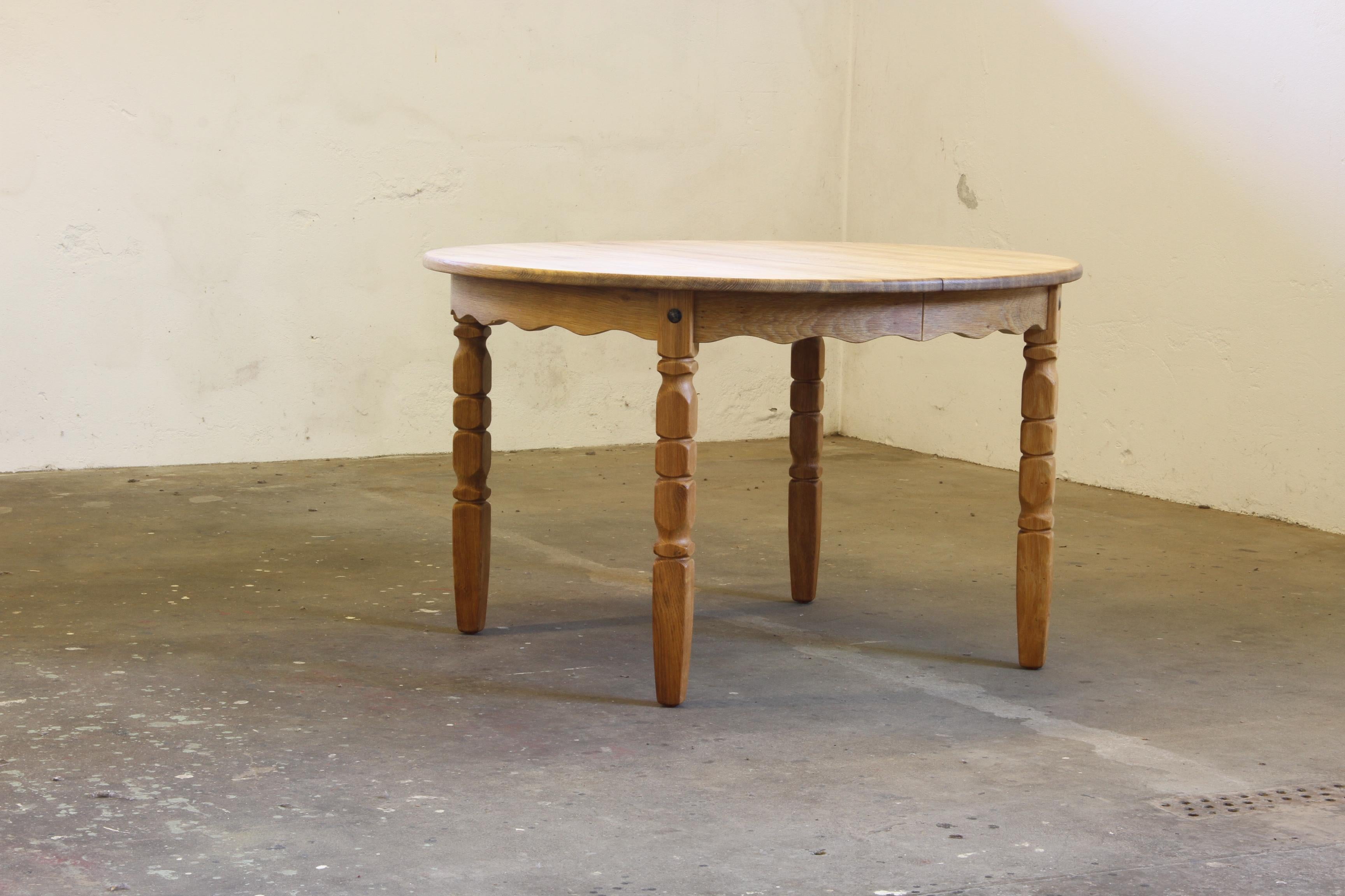 This vintage oak table captures the essence of Henning Kjærnulf's design philosophy, blending a bold brutalist aesthetic with refined craftsmanship. The intricate leg carvings harmonize beautifully with the table's rounded shape, creating a piece