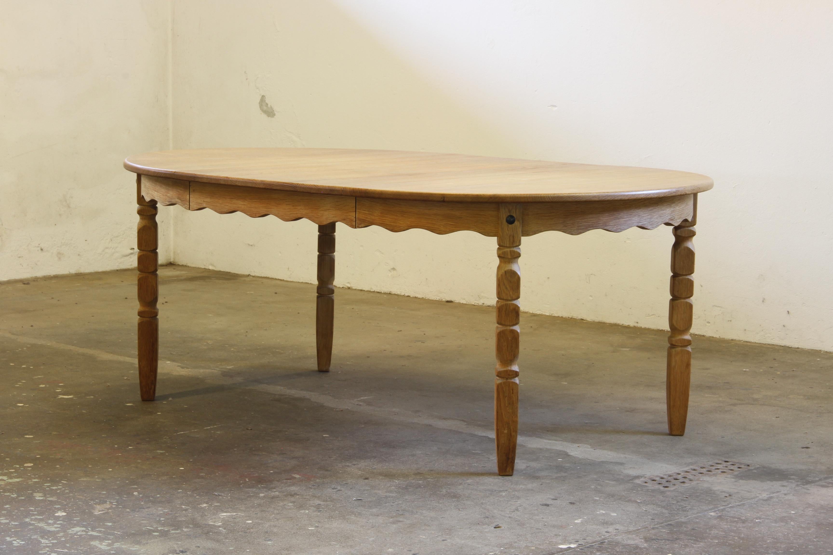 This vintage oak table captures the essence of Henning Kjærnulf's design philosophy, blending a bold brutalist aesthetic with refined craftsmanship. The intricate leg carvings harmonize beautifully with the table's rounded shape, creating a piece