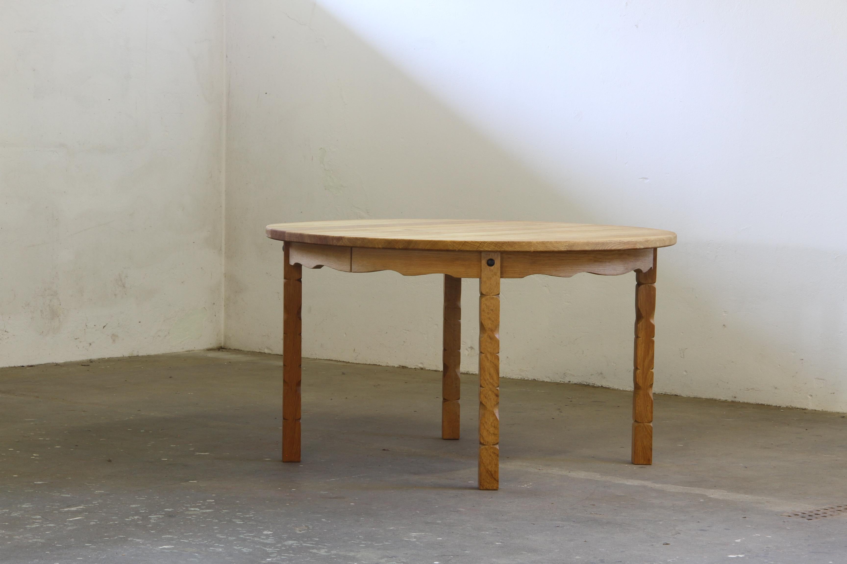 Questo tavolo vintage in rovere cattura l'essenza della filosofia di design di Henning Kjærnulf, fondendo un'audace estetica brutalista con una raffinata maestria artigianale. Gli intricati intagli delle gambe si armonizzano perfettamente con la