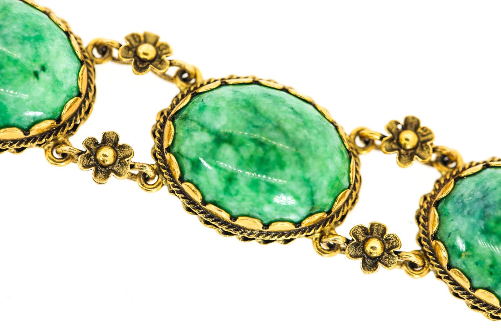 A special hand assembled bracelet features six oval cabochon natural green Jade average size stones.  Each Jade is set in a 14KT yellow gold scalloped bazel frame, accented with two different twisted ropes and joined by two gold flowers.  The 7.5