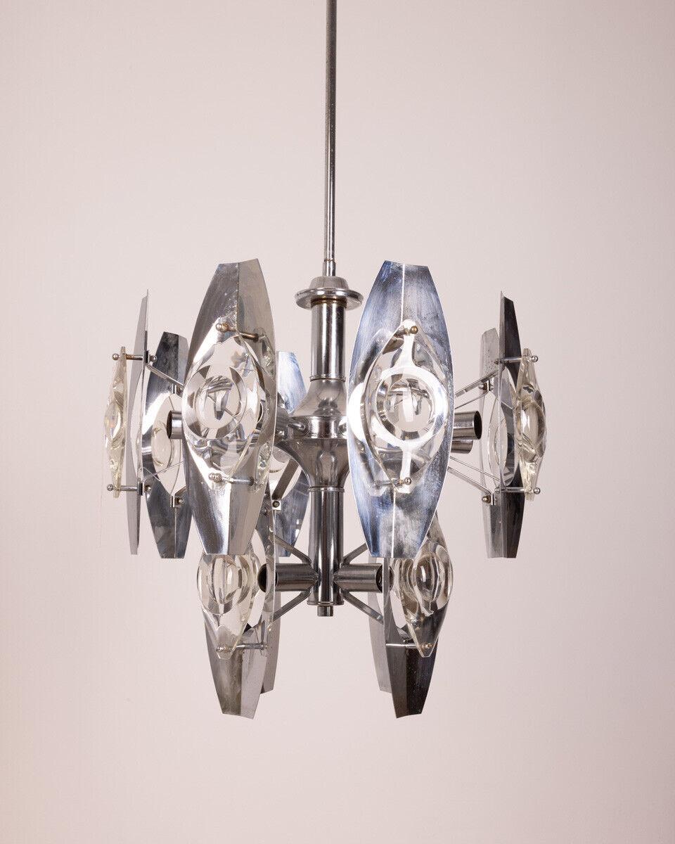 Chromed steel chandelier with twelve total lights with lenticular glass lampshades, design Oscar Torlasco, 1960s.

Conditions: In good condition, working, it may show signs of wear due to time.

Dimensions: Height 117 cm; Diameter 50