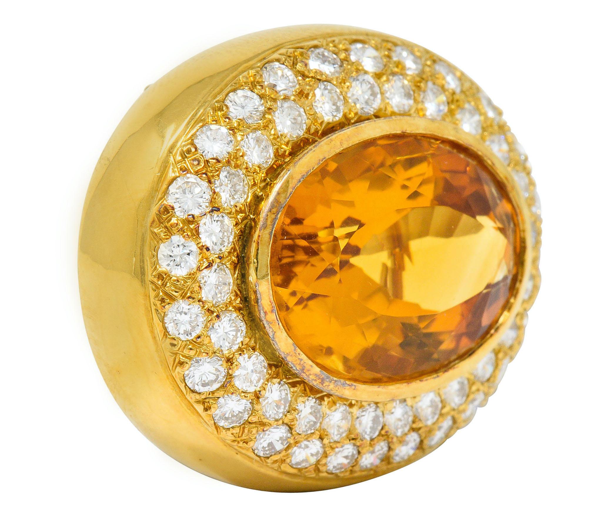 Centering a bezel set mixed oval cut citrine measuring approximately 19.0 x 14.0 mm

Transparent with strong orange color, uniform in distribution

Surrounded by pavè set round brilliant cut diamonds weighing in total approximately 2.00 carats; G/H