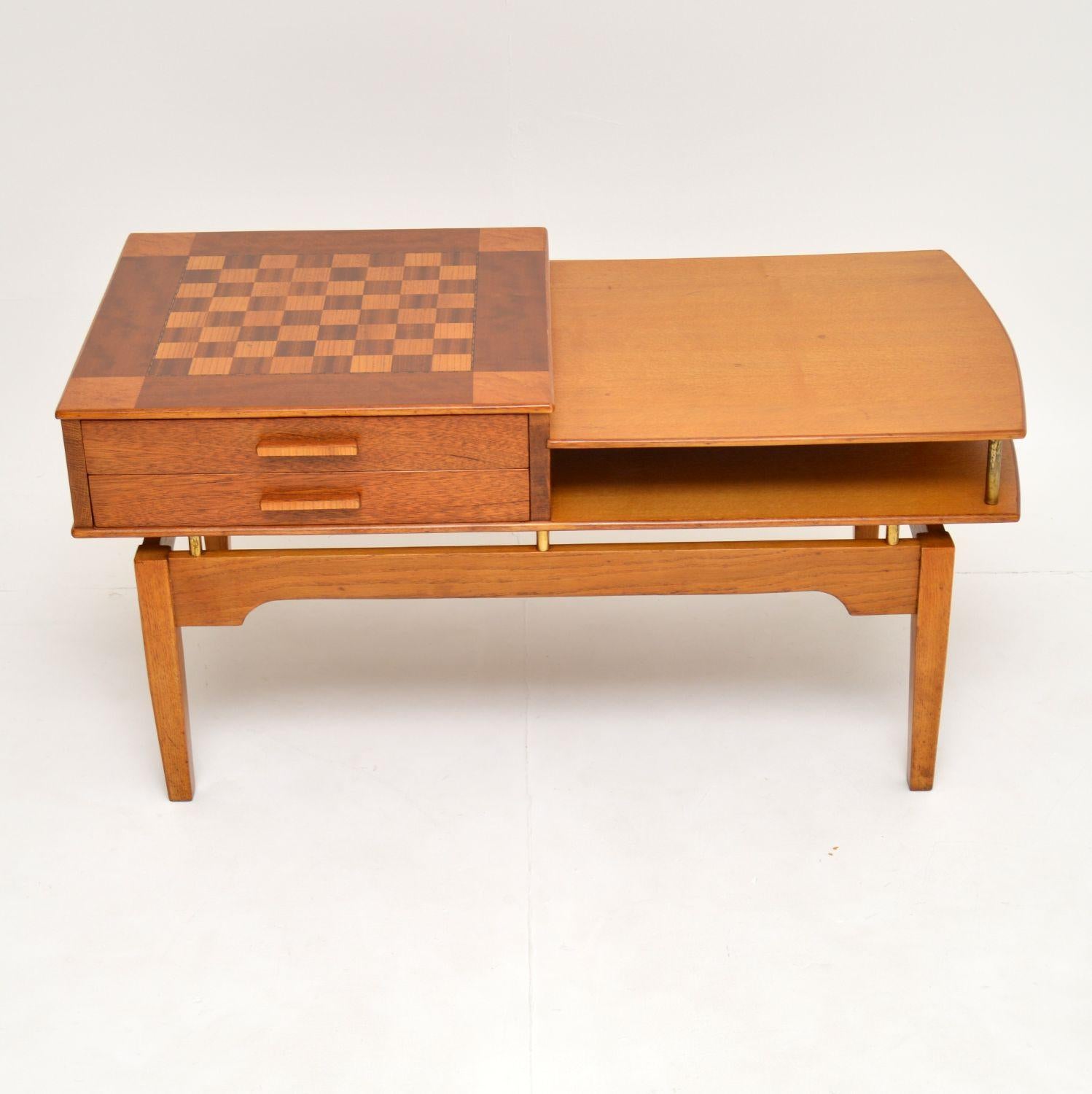 A beautiful and unusual vintage coffee table with an inlaid chessboard on the top. This dates from the 1960s and is made from several different woods; from what we can see there is mahogany, walnut and maple.

There are also lovely brass fixtures,