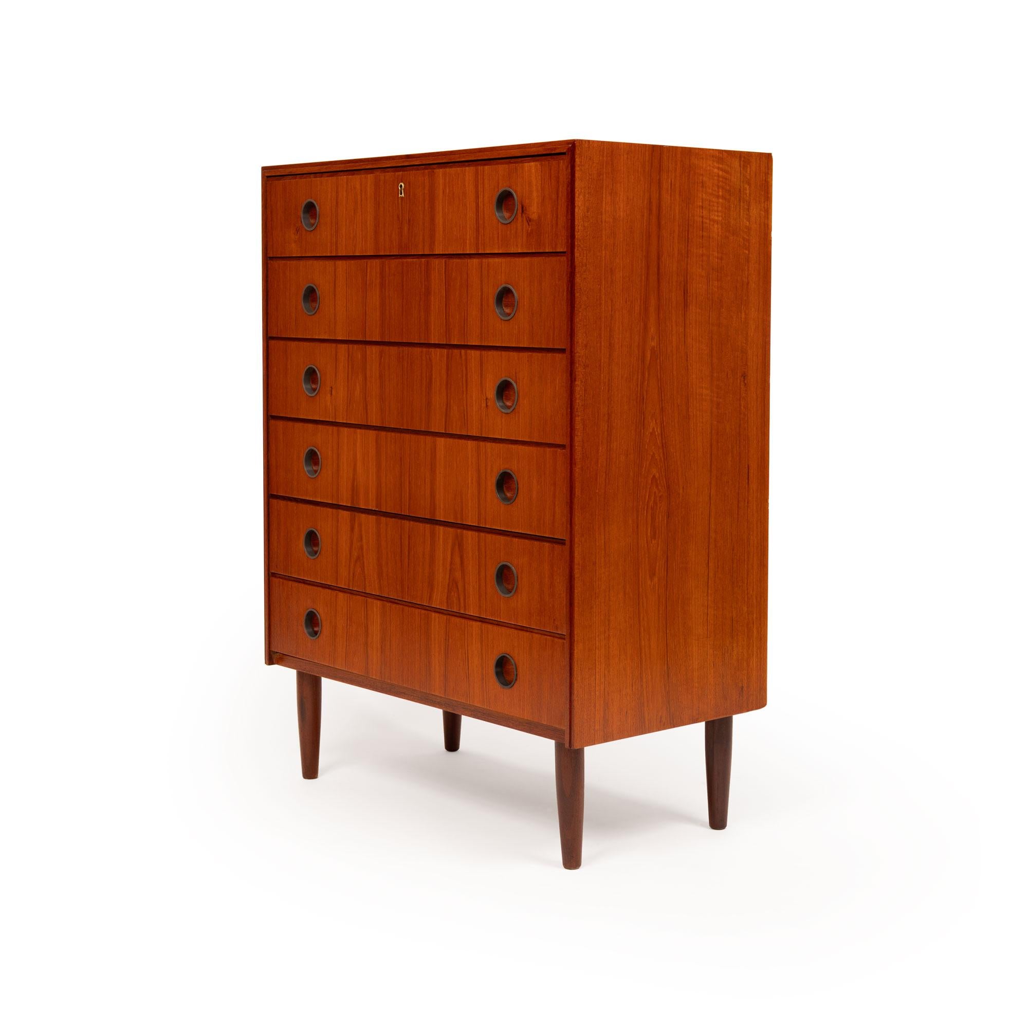 Fabriqué de manière experte au Danemark dans les années 1960, cet élégant buffet en teck du milieu du siècle est un bel exemple de design scandinave intemporel. Dotée de six tiroirs spacieux avec des poignées circulaires encastrées distinctives, la