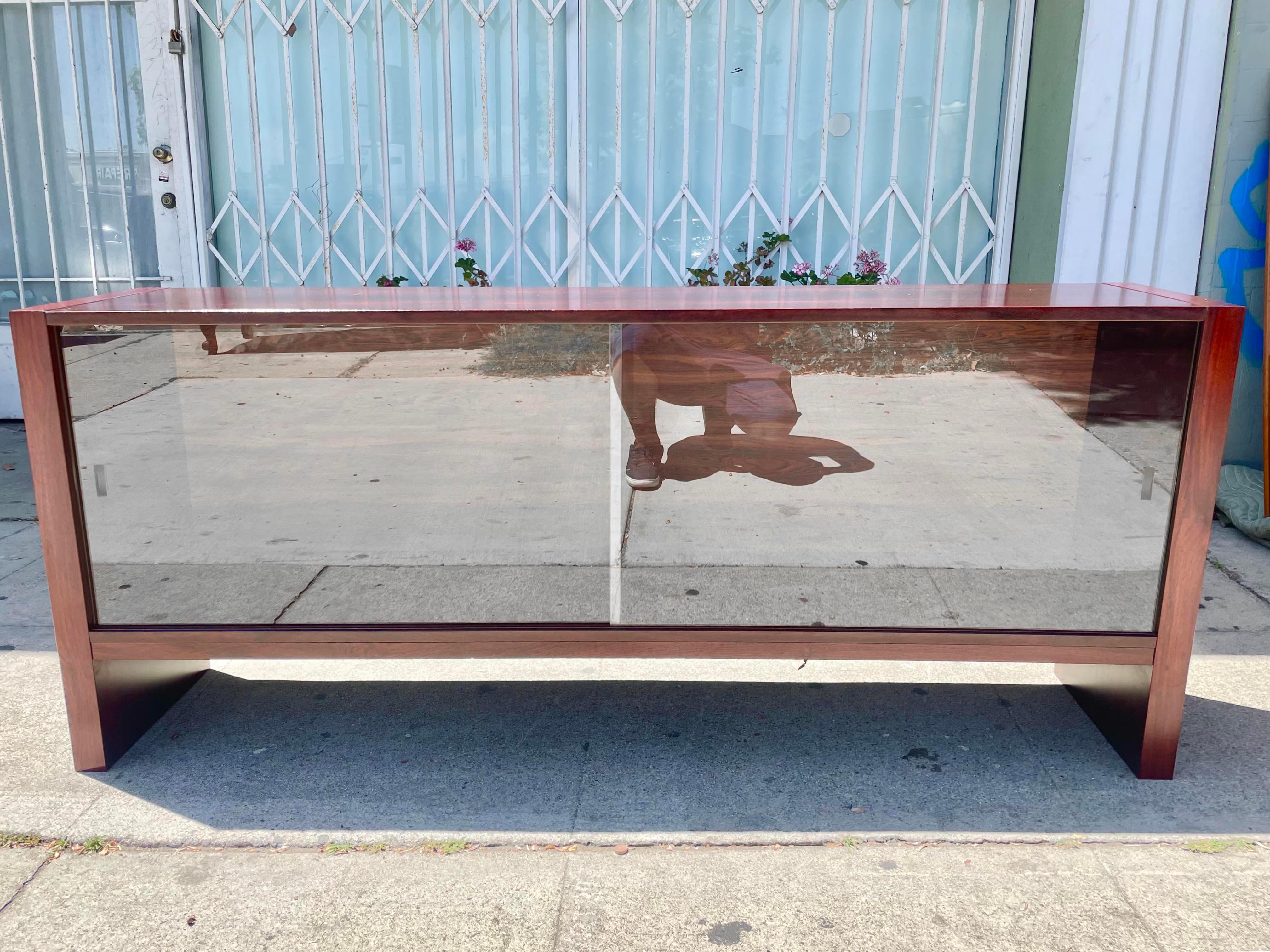 Danish modern rosewood bookcase designed and manufactured in Denmark circa 1960s. The intricate patterns of the rosewood grain give the piece a distinctive character that is sure to impress. The bookcase features two elegant glass sliding doors,