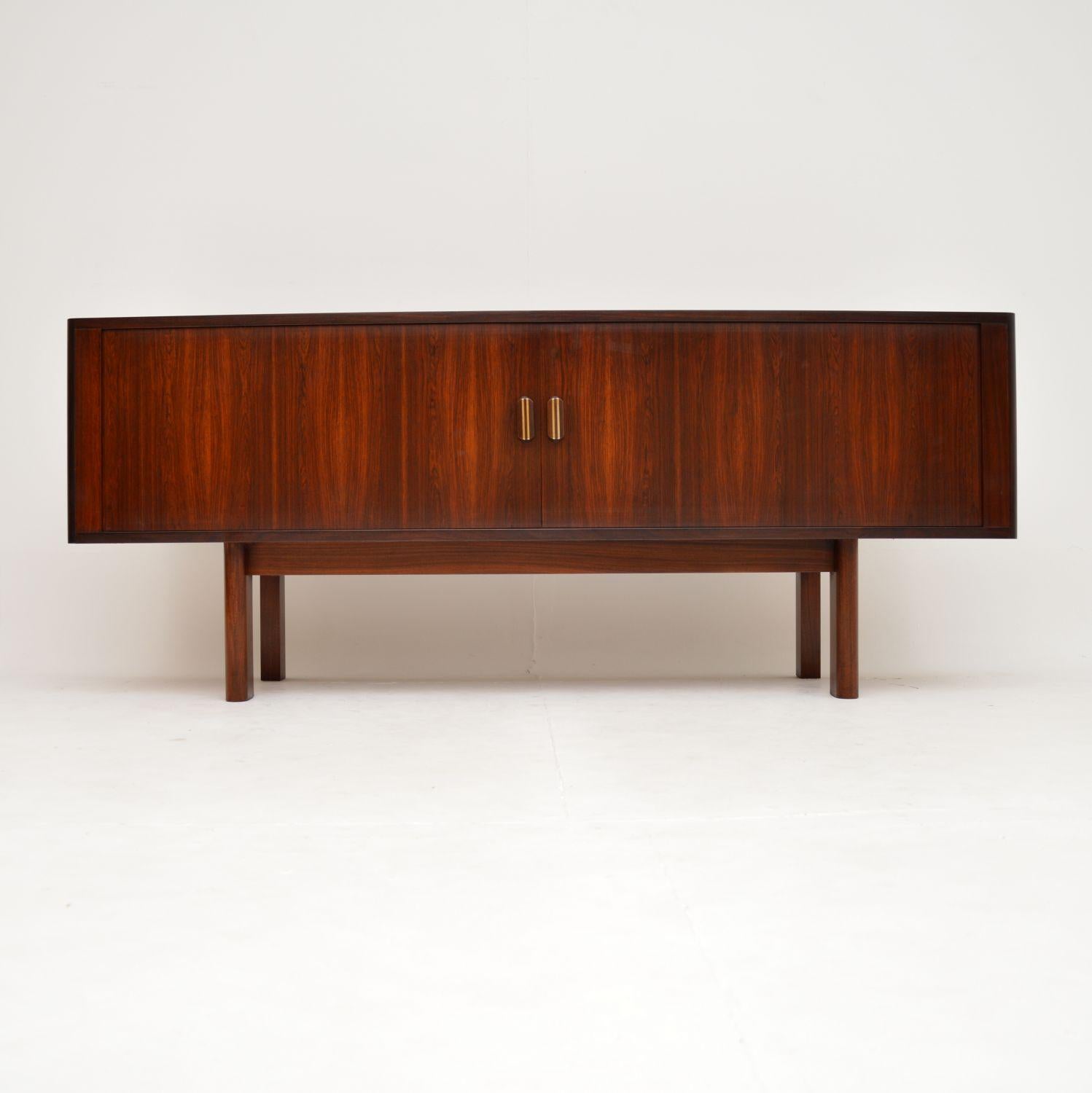 A magnificent vintage Danish tambour front sideboard. This was designed by Arne Vodder and was made by Sibast around the 1960’s.

This is of absolutely amazing quality, with stunning wood grain patterns throughout. The tambour doors roll back to