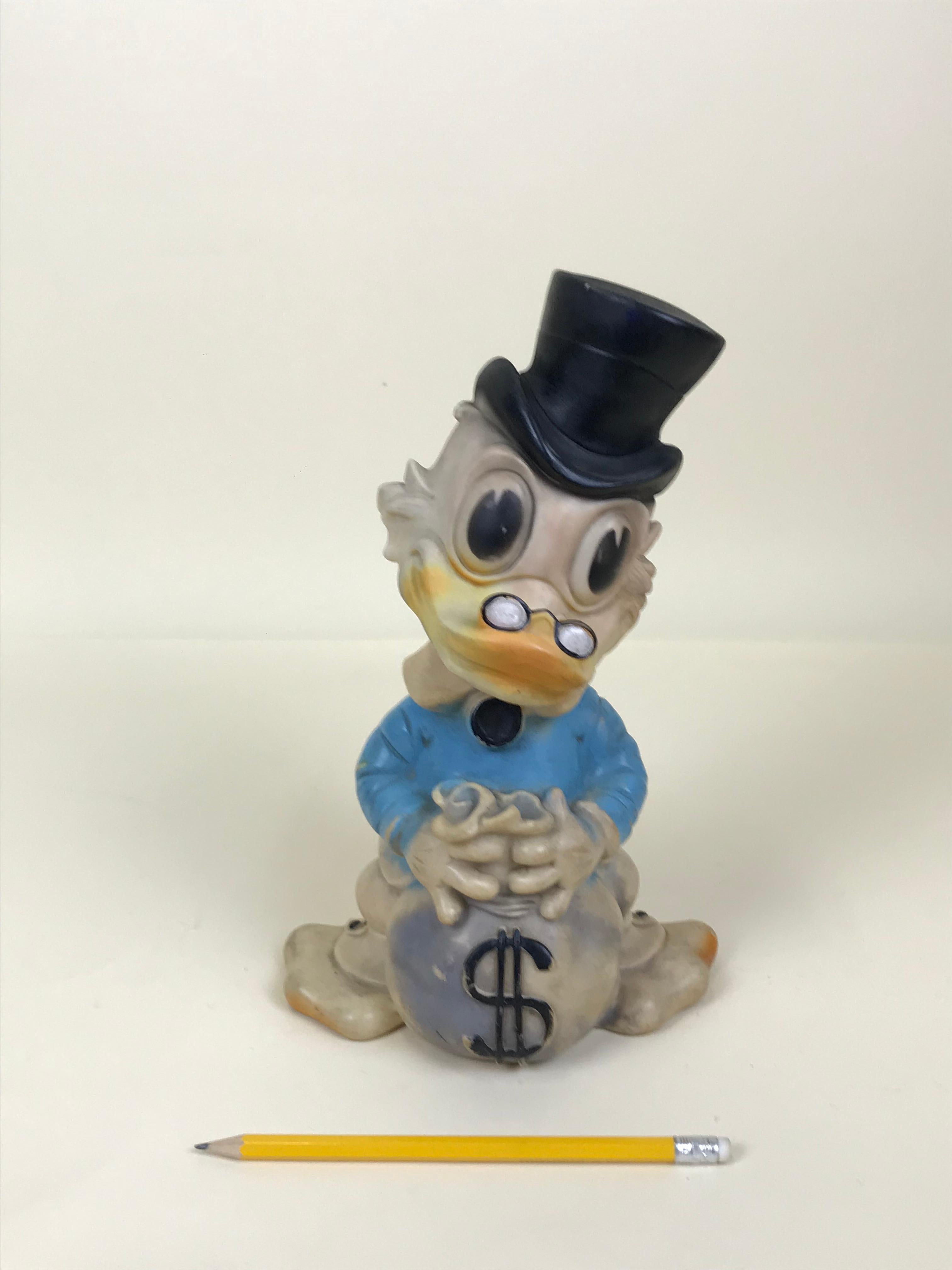 Very rare vintage blue Uncle Scrooge squeak rubber toy with bag of coins made by Biserka in ex Yugoslavia now Croatia in the 1960s.

This model is one of the six different color model originally produced.

Marked 