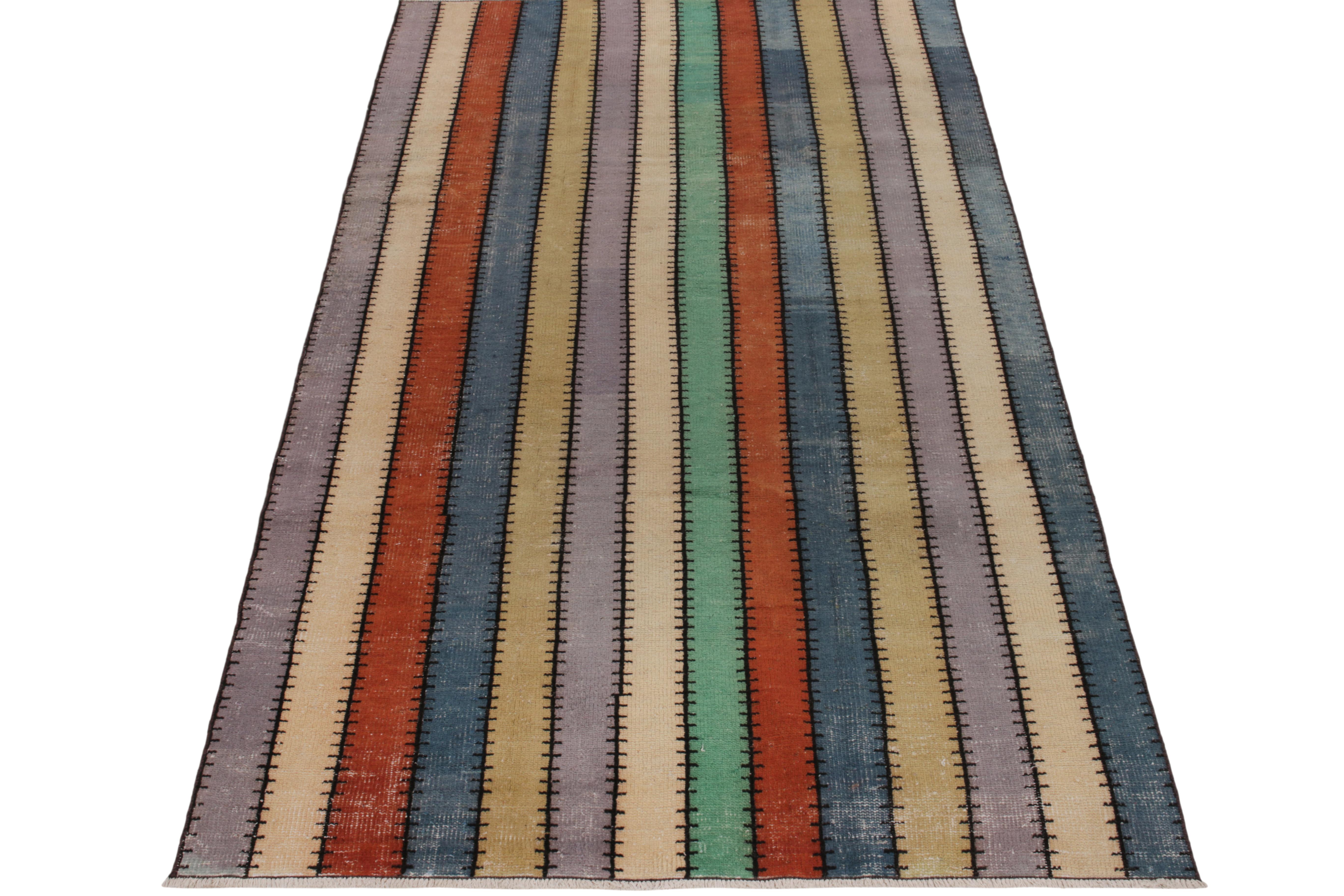 Hand-knotted in wool, a 5x9 vintage rug from a bold multidisciplinary Turkish designer commemorated in Rug & Kilim’s Mid-Century Pasha Collection. Featuring a neat striped pattern in tones of blue, red, beige, green & lilac, the rug exemplifies