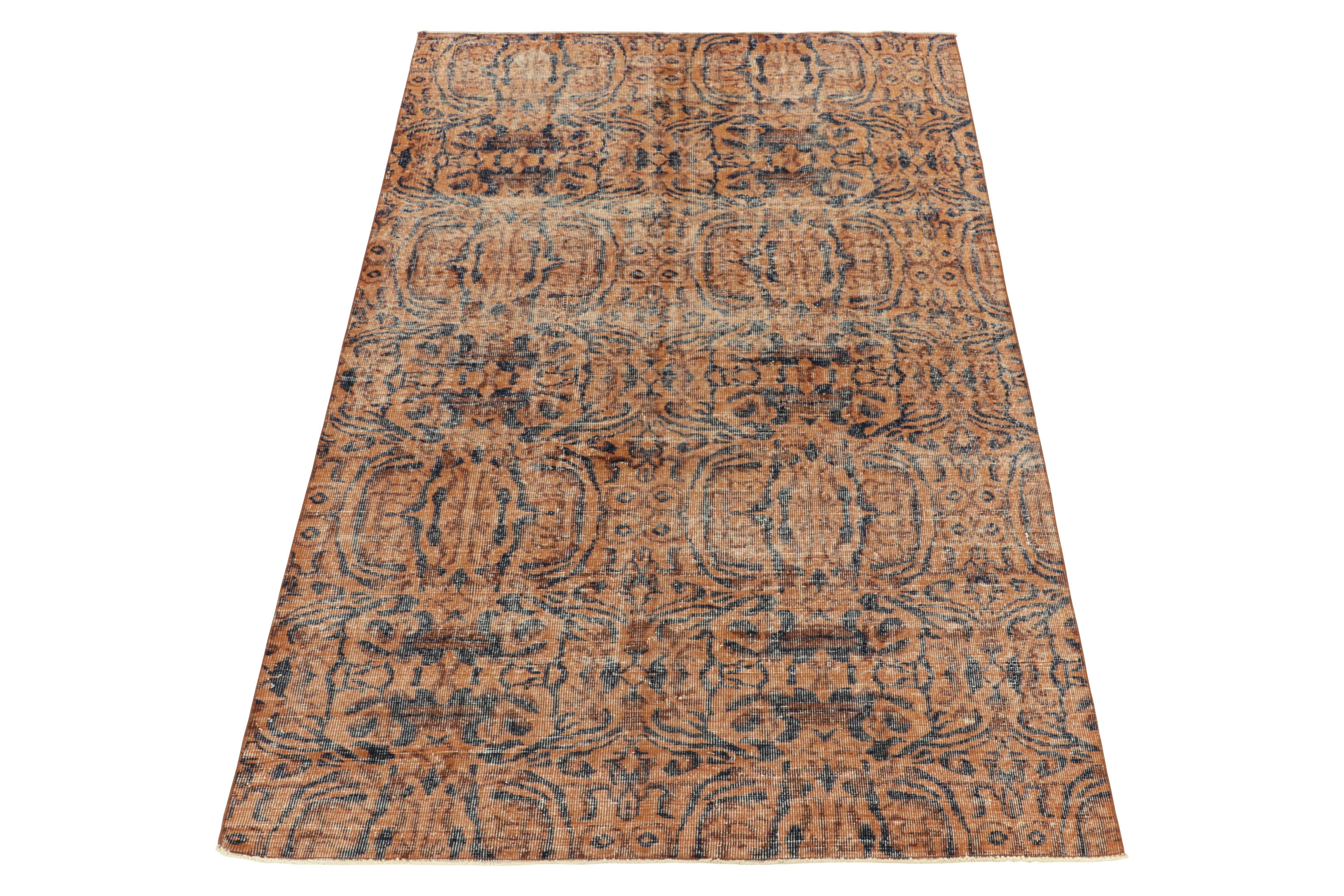 Noué à la main en laine de Turquie vers 1960-1970, ce tapis vintage 5x8 en mauvais état, créé par un artiste turc renommé, fait partie de la collection Pasha du milieu du siècle de Rug & Kilim. Jouant sur l'orange avec le marron et un bleu nuit