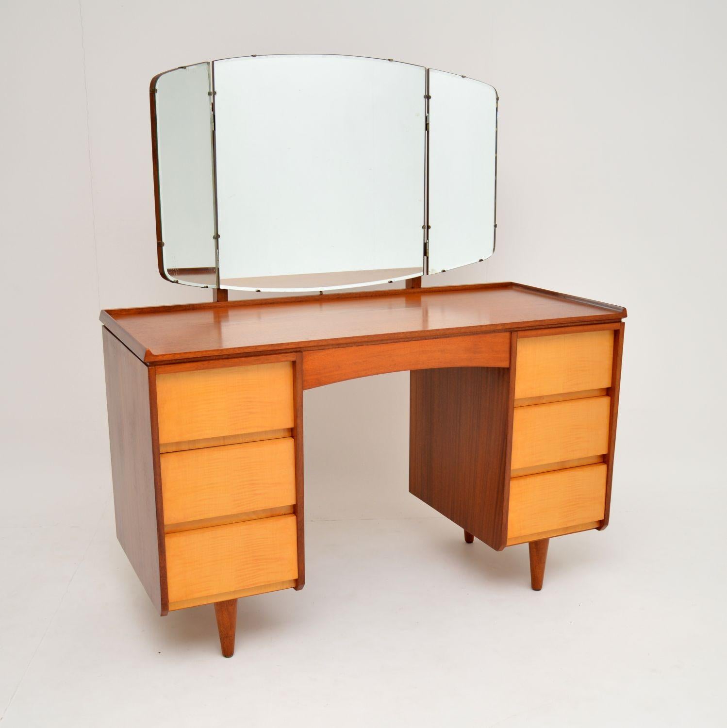 A beautiful vintage dressing table of super high quality, this dates from the 1960’s.

It has a walnut top and sides, with lovely sycamore fronted drawers. We have had this stripped and re-polished to a very high standard, the condition is superb