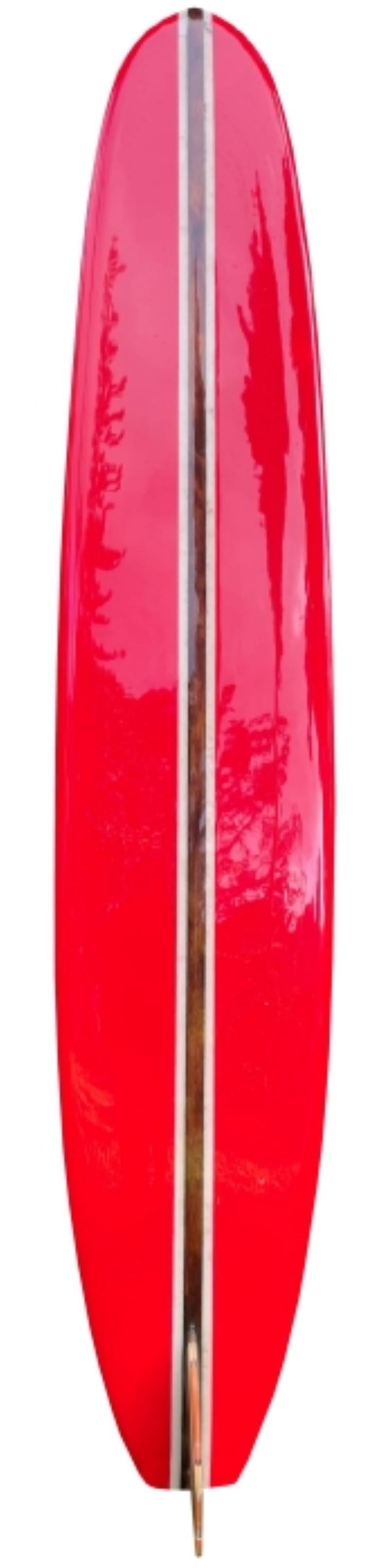 Mid-1960s Duke Kahanamoku Hawaiian style 9’9 classic longboard made in the mid 1960s. Features attractive red panels, single wood stringer design, and stunning 17 piece redwood/balsa wood fin. A fantastic example of a 1960s vintage longboard bearing