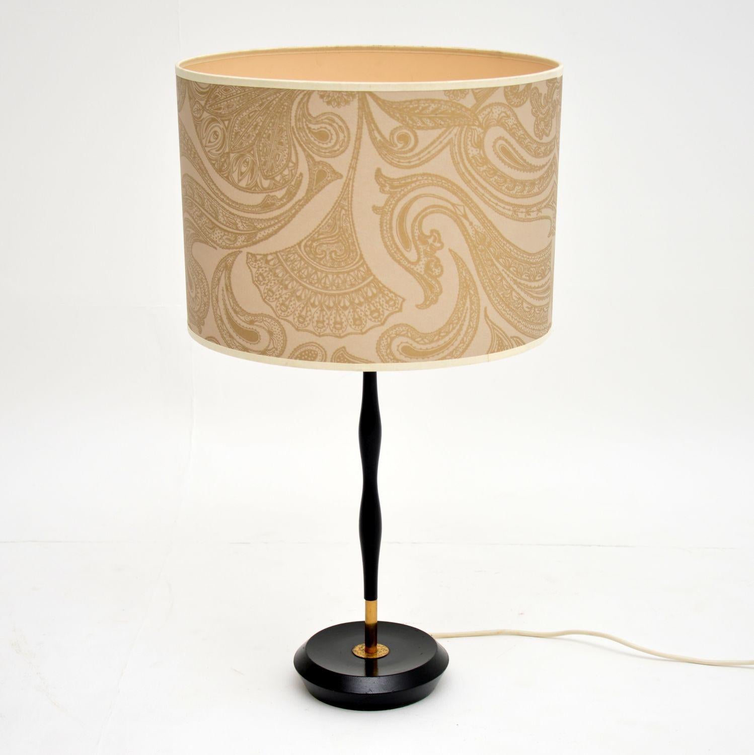 A beautifully styled vintage table lamp in ebonized wood, with brass accents. This is of great quality; it dates from the 1960s. The condition is very good for its age, with just some minor surface wear here and there. This is in good working order,
