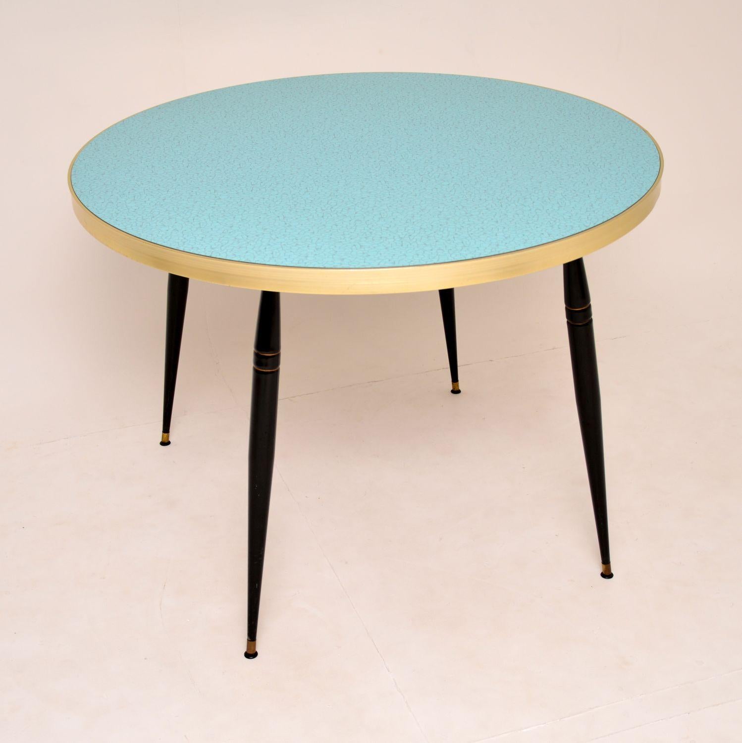 Une table à manger circulaire vintage étonnante des années 1960. C'est l'un des plus beaux exemples que nous ayons jamais vus. Il est très audacieux et élégant:: et de qualité supérieure également. 

Le dessus en Formica bleu pâle présente un motif