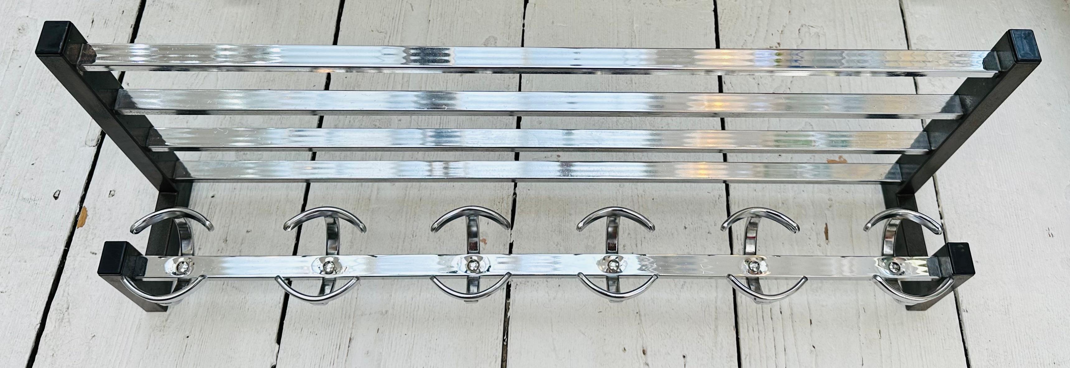 A 1960s French vintage chrome and grey-coated metal wall hanging coat and hat rack. Very well made with grey-coated metal brackets which hooks to the wall with six double circular coat hooks and a four bar upper railed shelf.  An attractive design