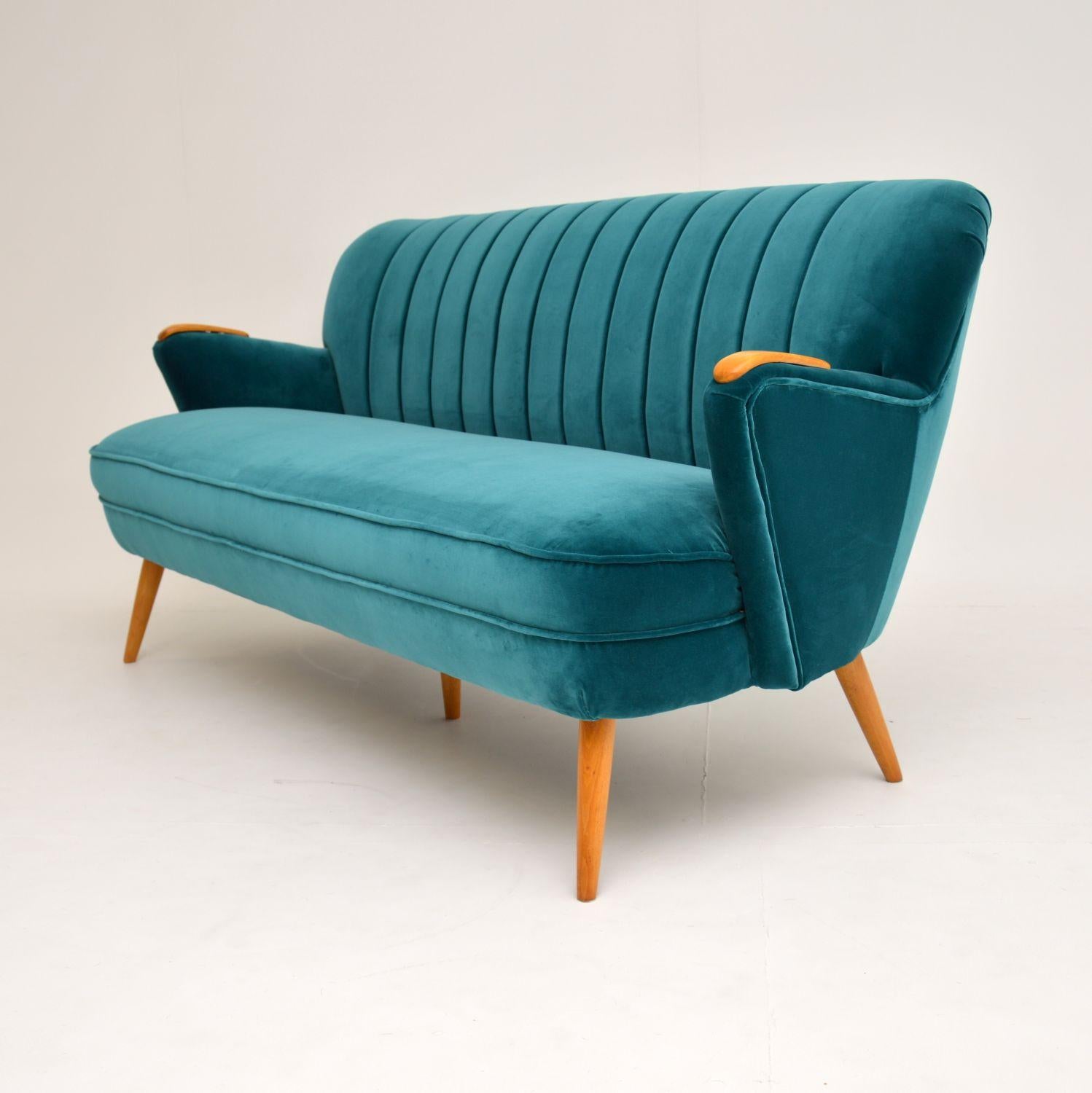 An absolutely stunning vintage cocktail sofa of the highest quality. This dates from the 1960s, it was made in Germany. We have had this completely restored, it is in perfect condition. We have had this re-upholstered in our lovely light green /