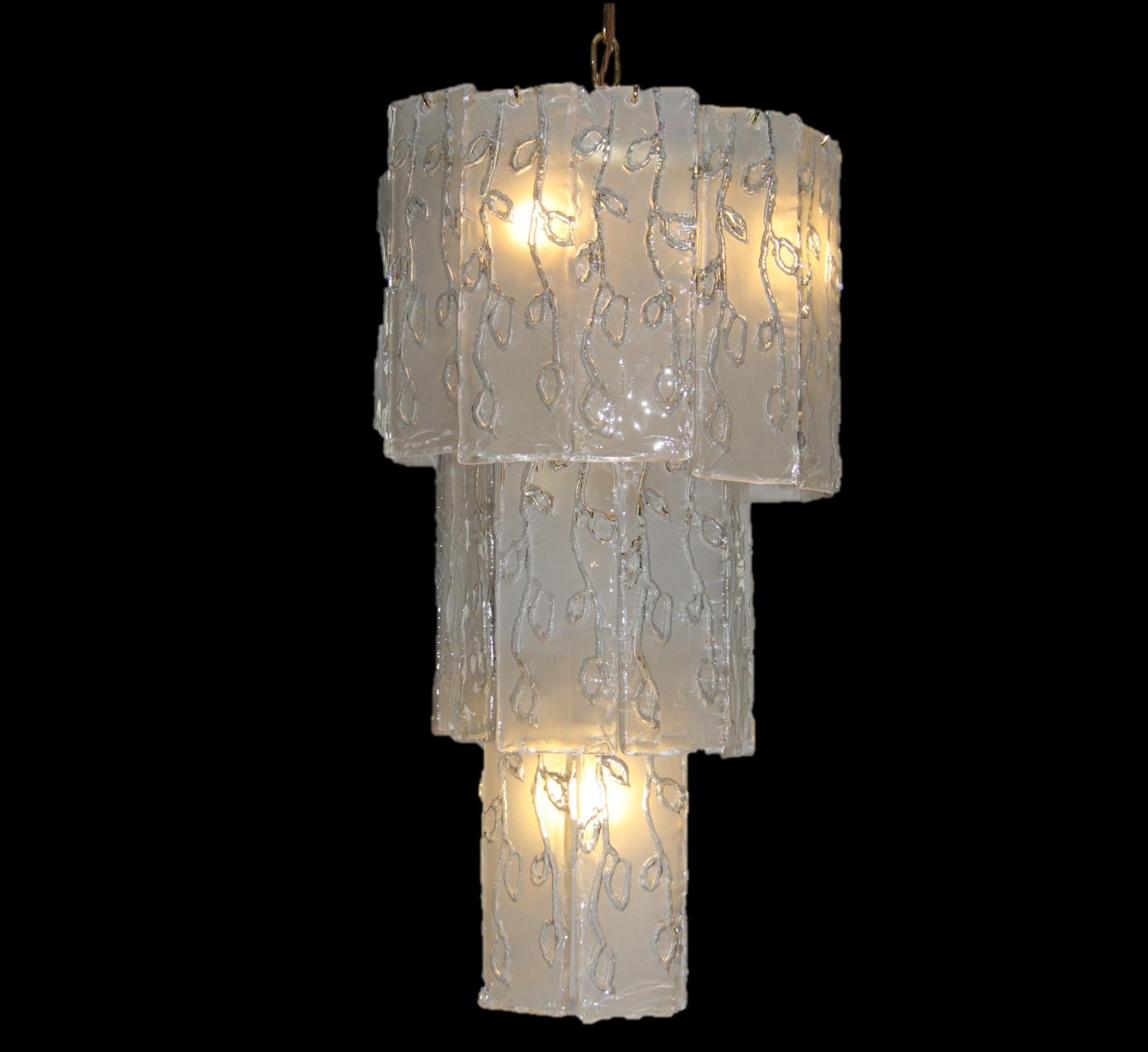 An absolutely stunning and extremely well made vintage chandelier, this dates from the 1960s. It has a brass frame and many frosted glass panels that hang from the frame in three tiers. The condition is superb for its age, this is wired and in good
