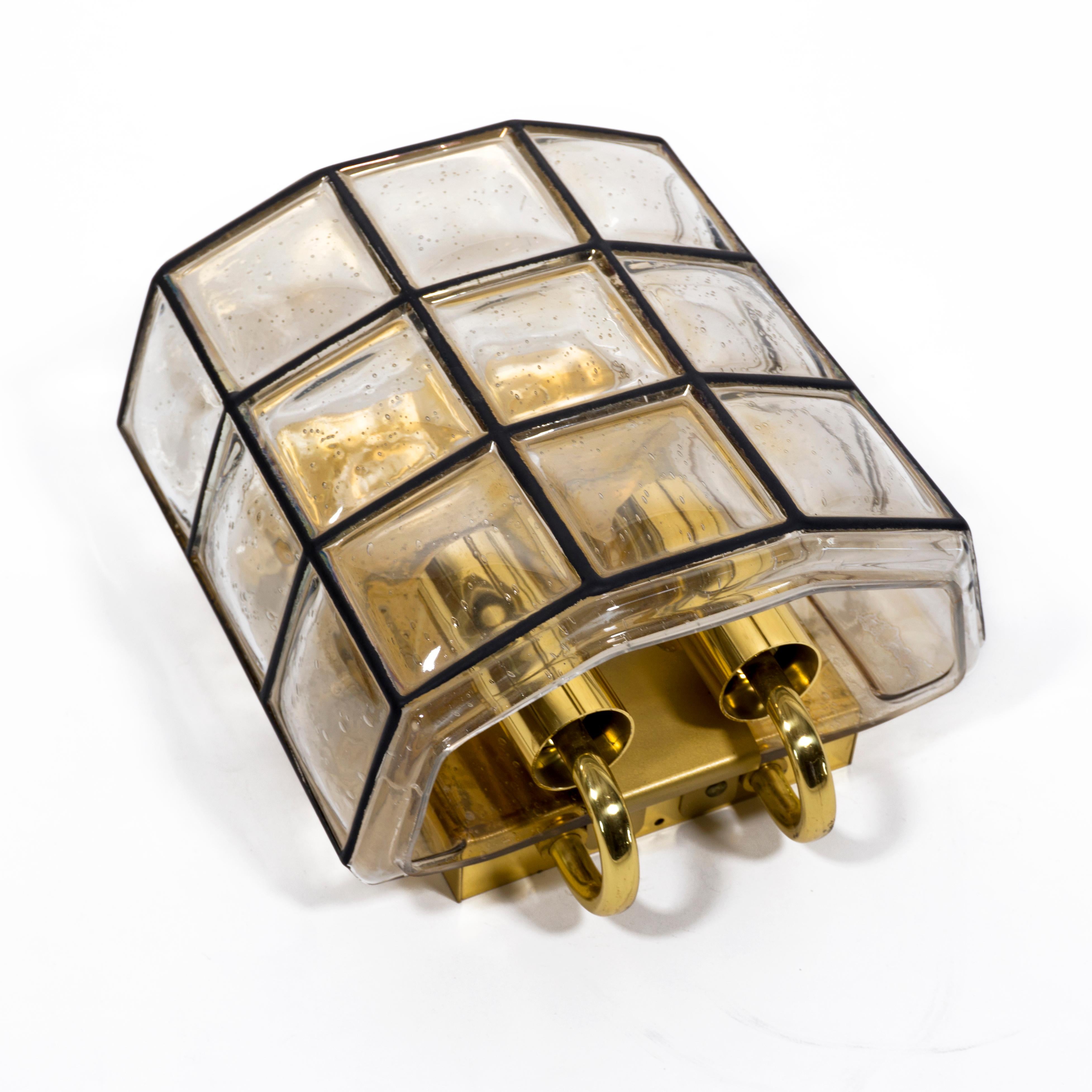 Elegant Limburg double socket wall light  wall sconce made of glass, iron and brass from the 1960s. 
The lamp has a shade made of iron and textured bubble glass. The hand-blown glass bulges slightly out of each individual iron square which gives the