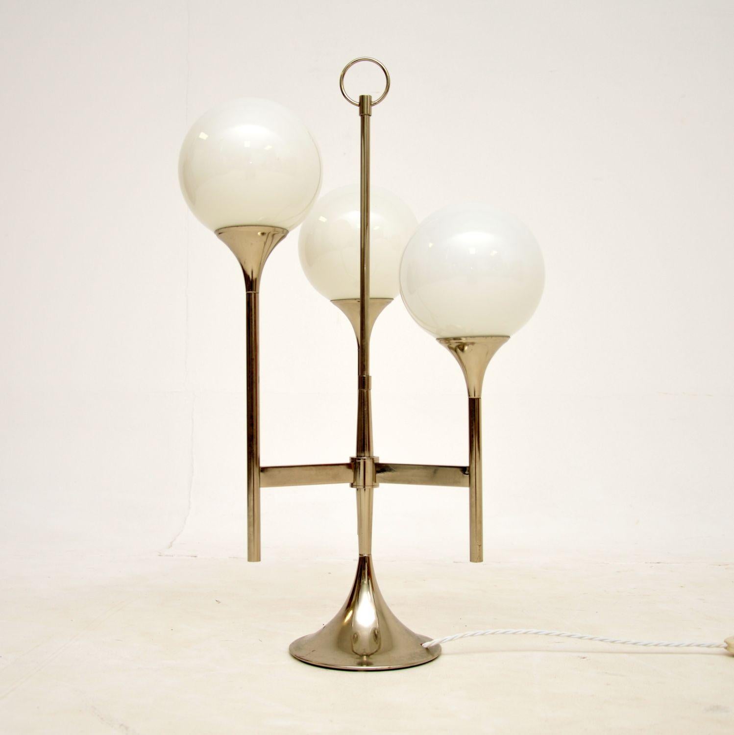 A stylish and very well made vintage table lamp in chromed steel and glass. This was made in Italy, it dates from around the 1960-70s..

It is of superb quality and has a wonderful design, with three glass spherical shades. The chromed steel frame