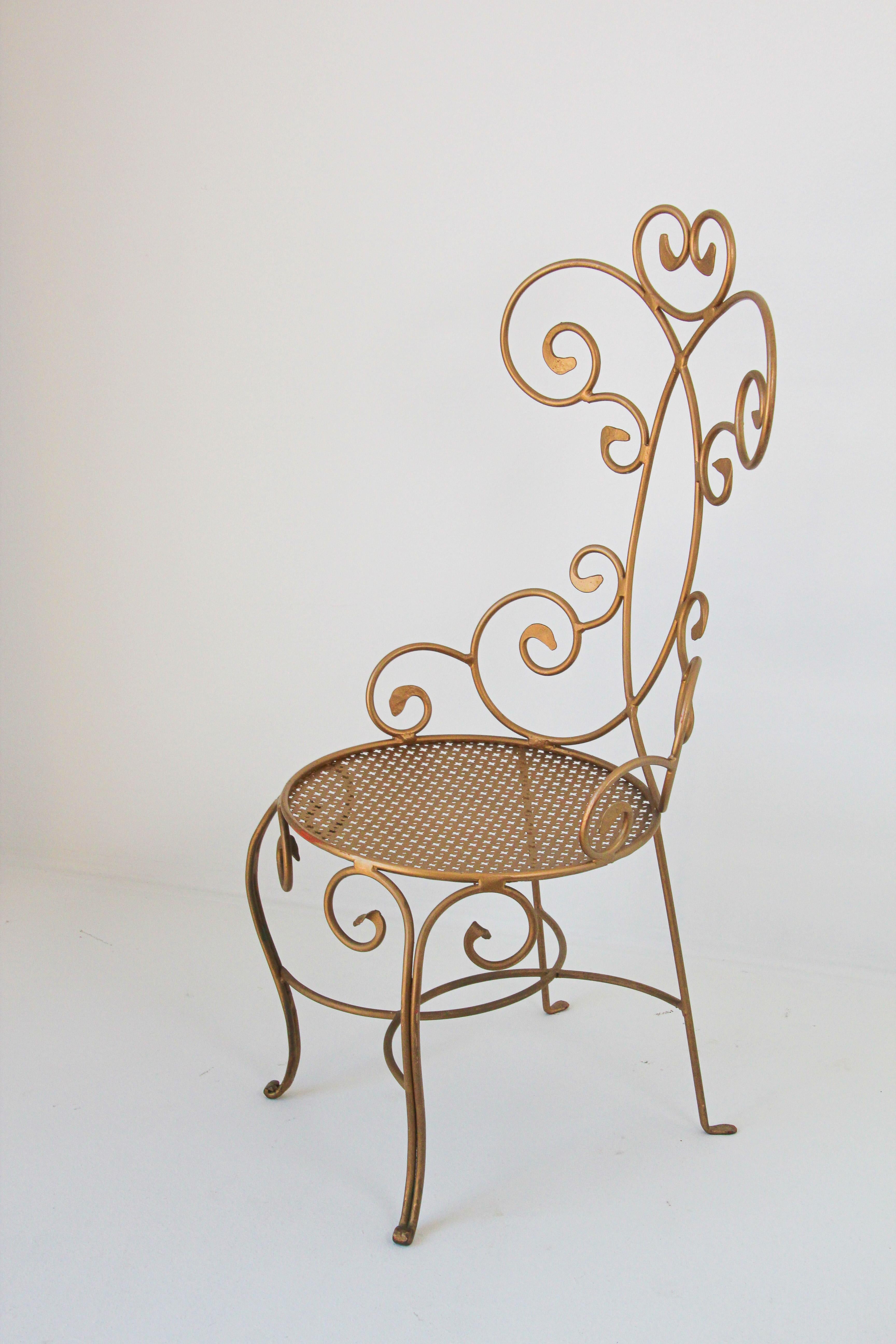 1960s vintage Italian Hollywood Regency gilt iron vanity chair.
Petite Italian vanity side chair in gold gilt wrought iron, light weight and perfectly suited for a dressing room, music room, kids space, bedroom or vanity. 
This metal chair can be a