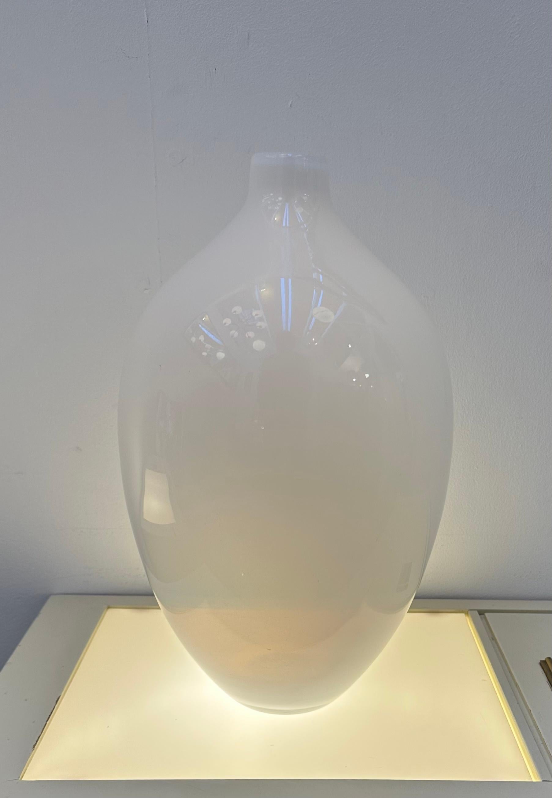 1960s vintage Italian handblown white opalescent milky-white glass bottle vase in an ovoid form. An elegant vase, with a simple yet sophisticated design. The vase is made of white opalescent glass, which gives it a soft, glowing appearance. The vase