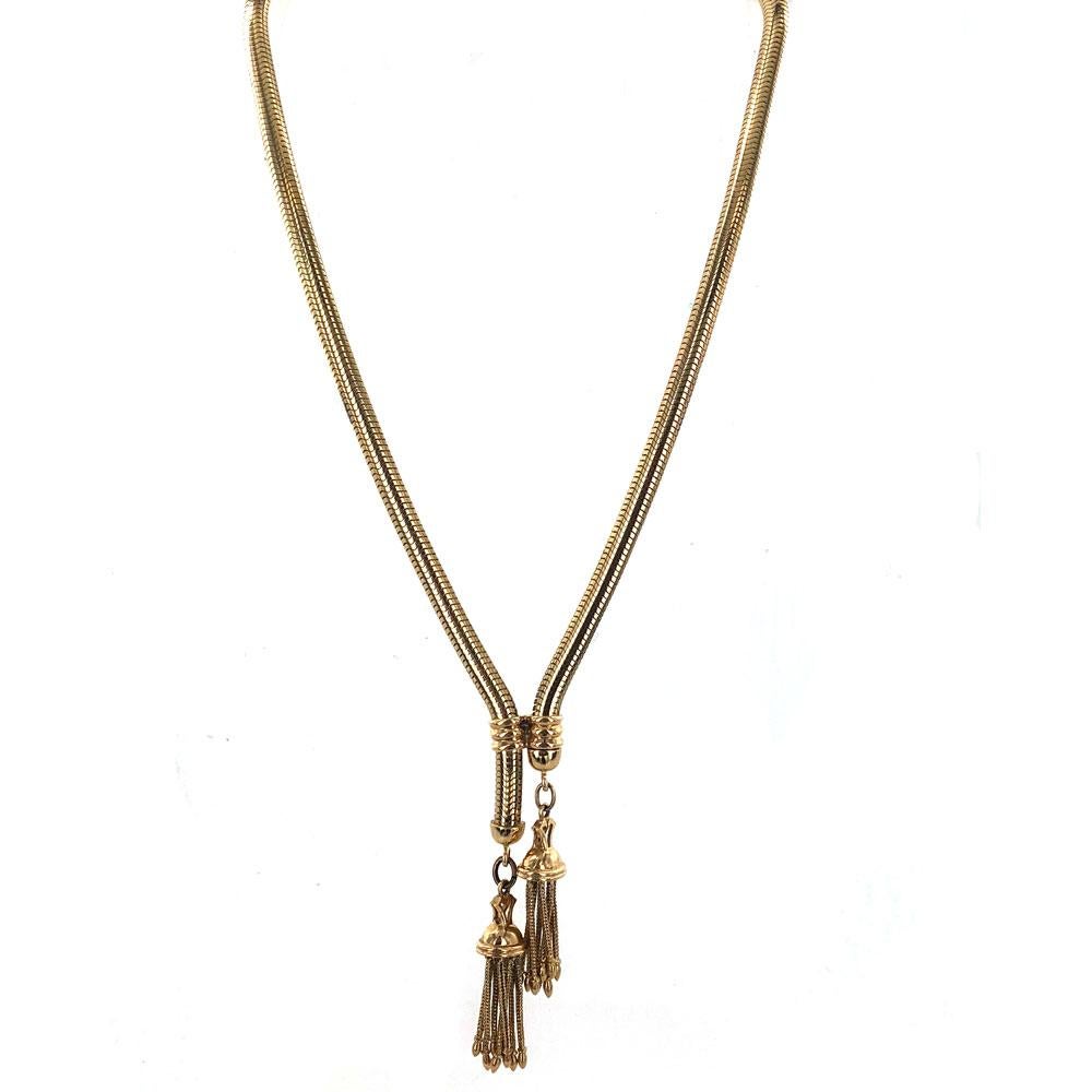 This stylish vintage lariat necklace is crafted in 14 karat yellow gold. The flexible snake like solid link measures 5mm in width and features tassel ends. The necklace can adjust to different lengths by sliding the tassels. It can be worn anywhere