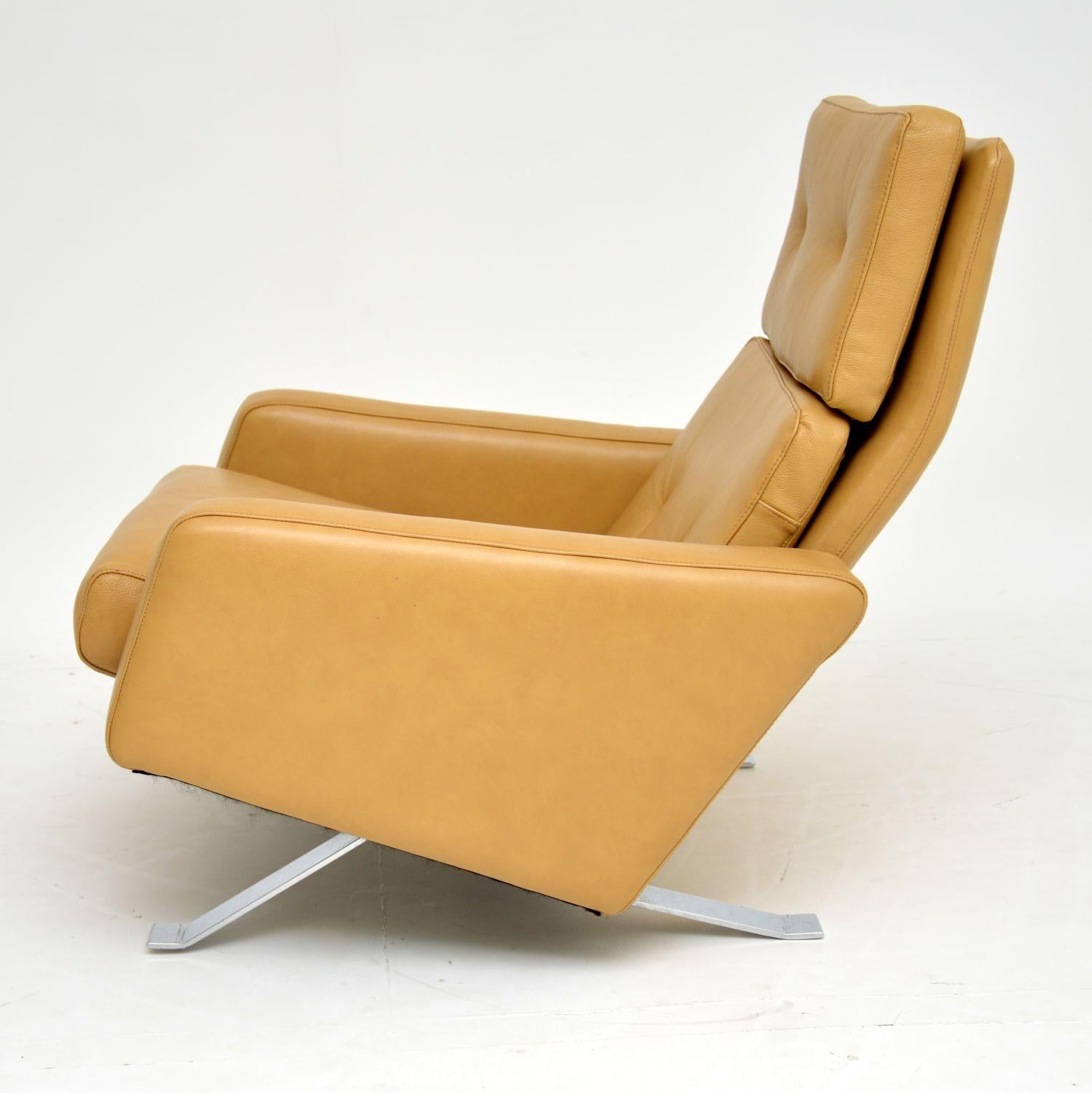 A stunning and iconic vintage leather armchair, designed by Robin Day for Hille, this is the “Leo” chair. This early model dates from the 1960s, we have had it completely re-upholstered in a beautiful tan leather. The chrome base is in fantastic
