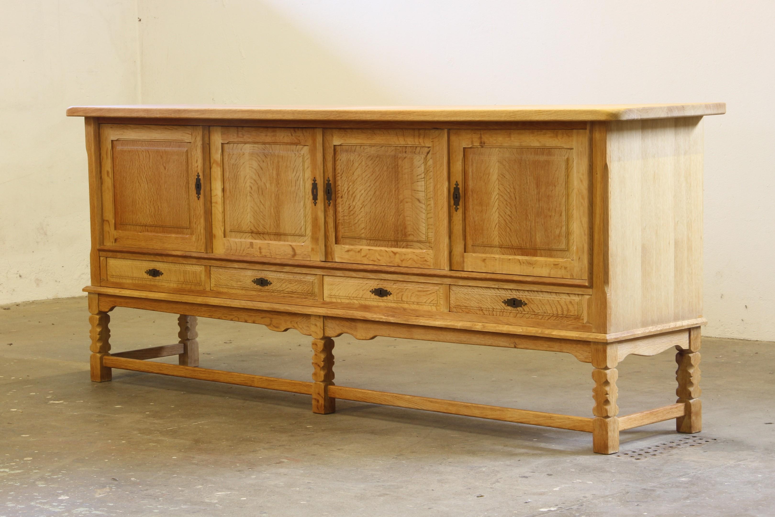 Ein schönes und gepflegtes Möbel aus massiver Eiche im Stil von Henning Kjærnulf. Die Holzart wird damals mit Säure behandelt. Dieses Verfahren entzieht der Oberfläche Feuchtigkeit und macht sie heller und rauer. Auch wenn der Schrank groß und