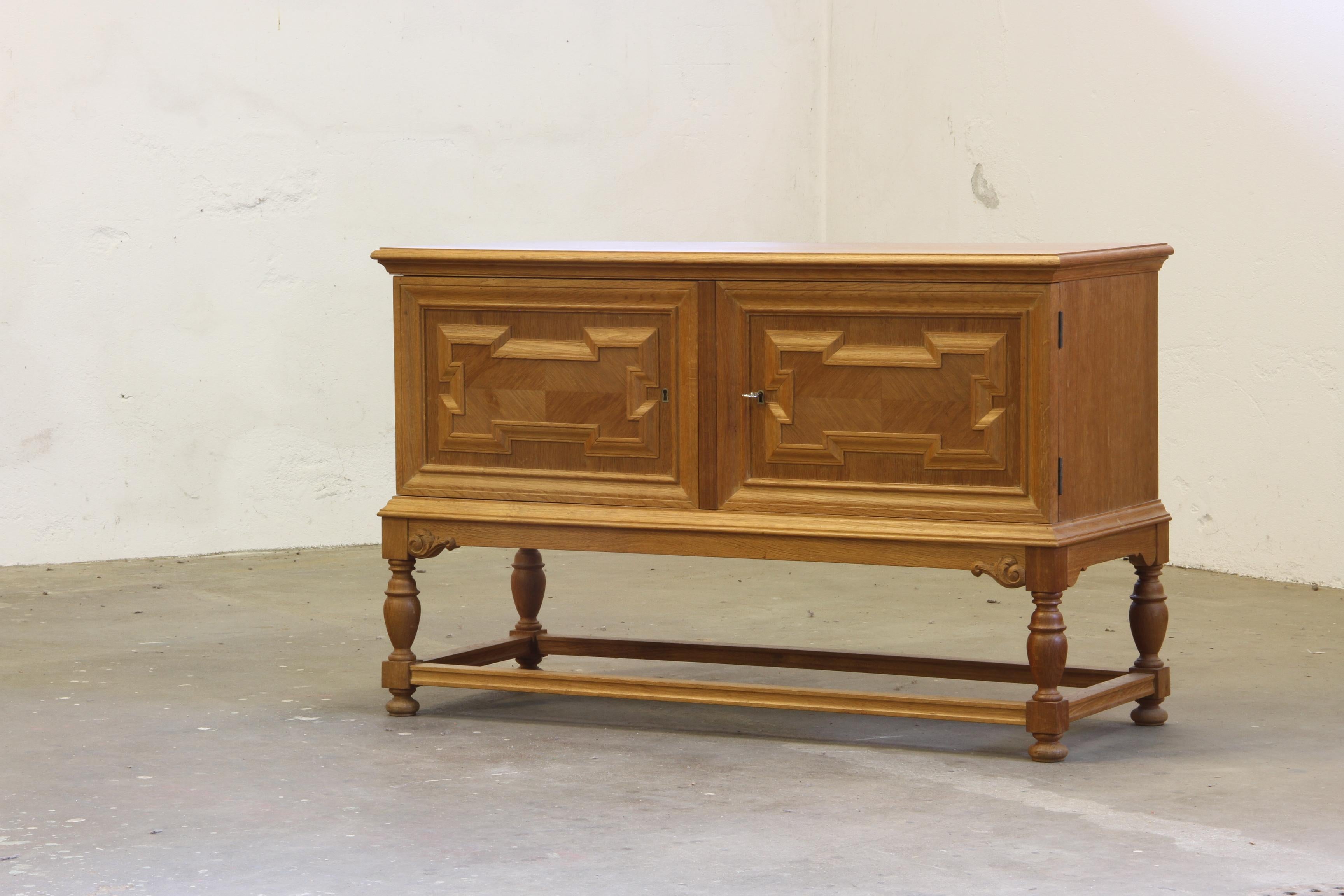 A rare and wellkept furniture in massive oak with a style of danish modern and some design similarities to the Brutalist and baroque style Henning Kjærnulf. Even though that the cabinet is big and heavy, it still feels slim and elegant. The squared