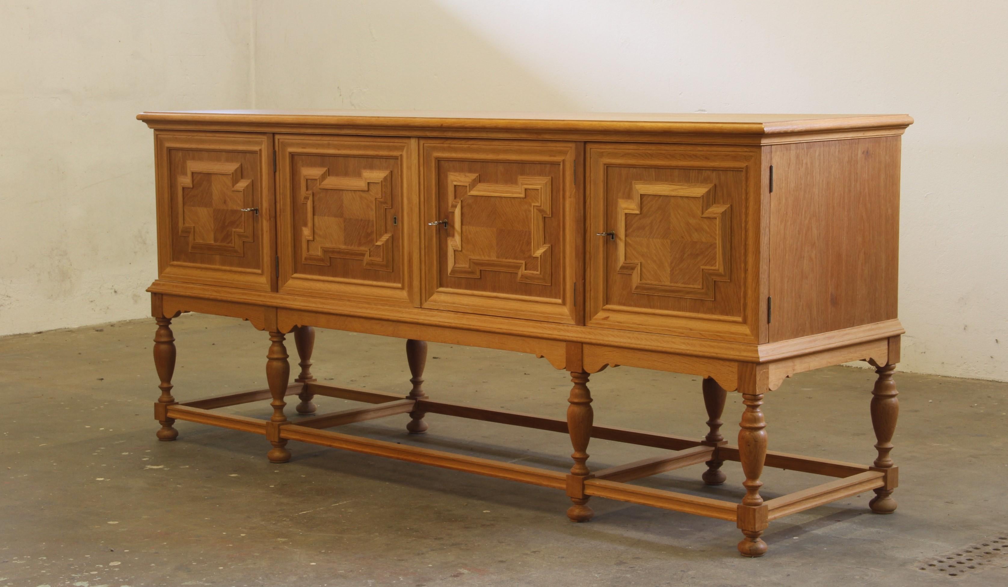 Ein seltenes und gut erhaltenes Möbel aus massiver Eiche mit einem Stil der dänischen Moderne und einigen Designähnlichkeiten zum Brutalismus und Barockstil Henning Kjærnulfs. Auch wenn der Schrank groß und schwer ist, wirkt er dennoch schlank und