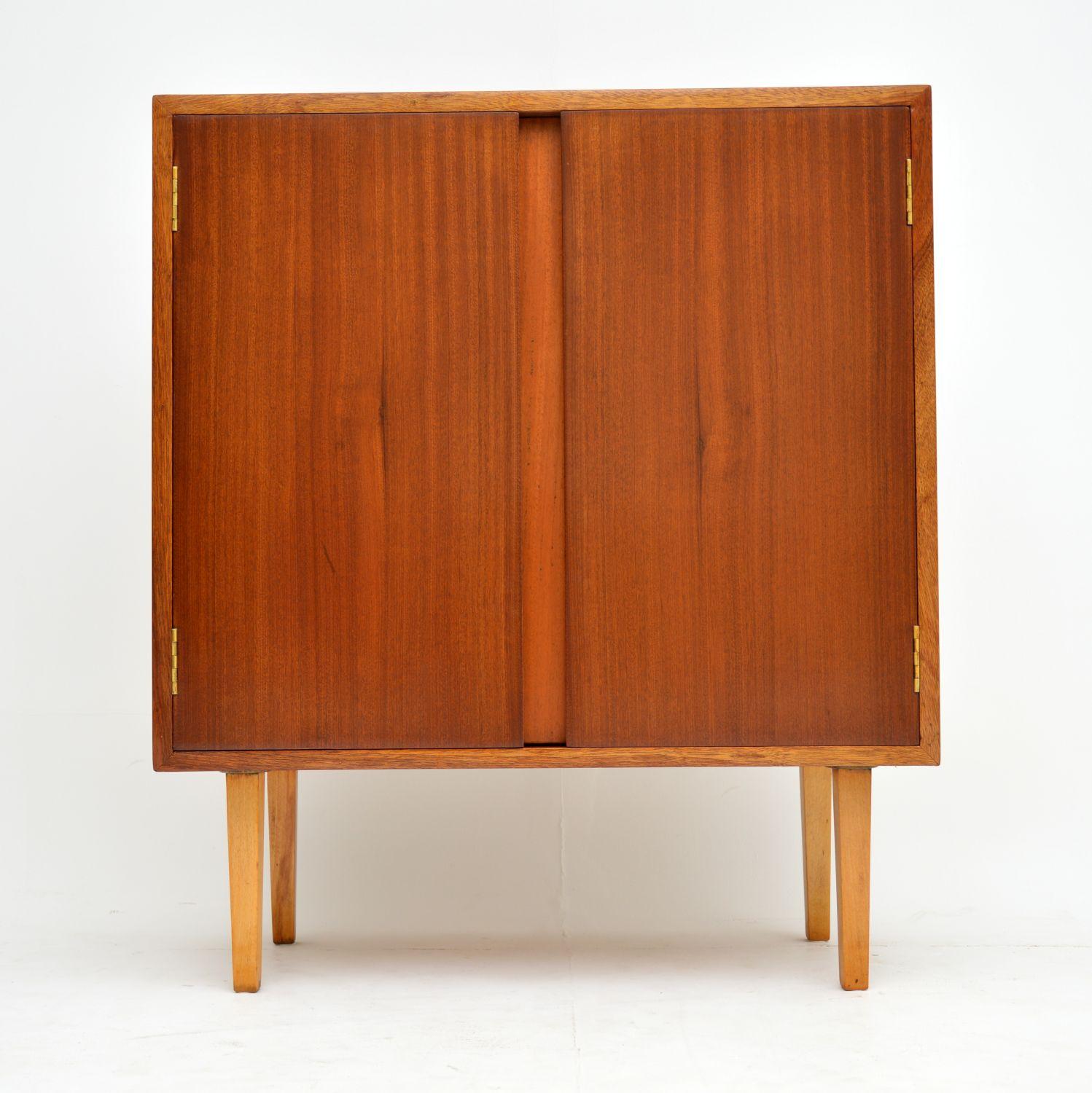 A smart and useful drinks cabinet from the 1960s, made from mahogany. This is very well made, it opens to reveal a formica topped serving area attached to the door. There are also built in shelves for glasses and a larger compartment for bottles. We
