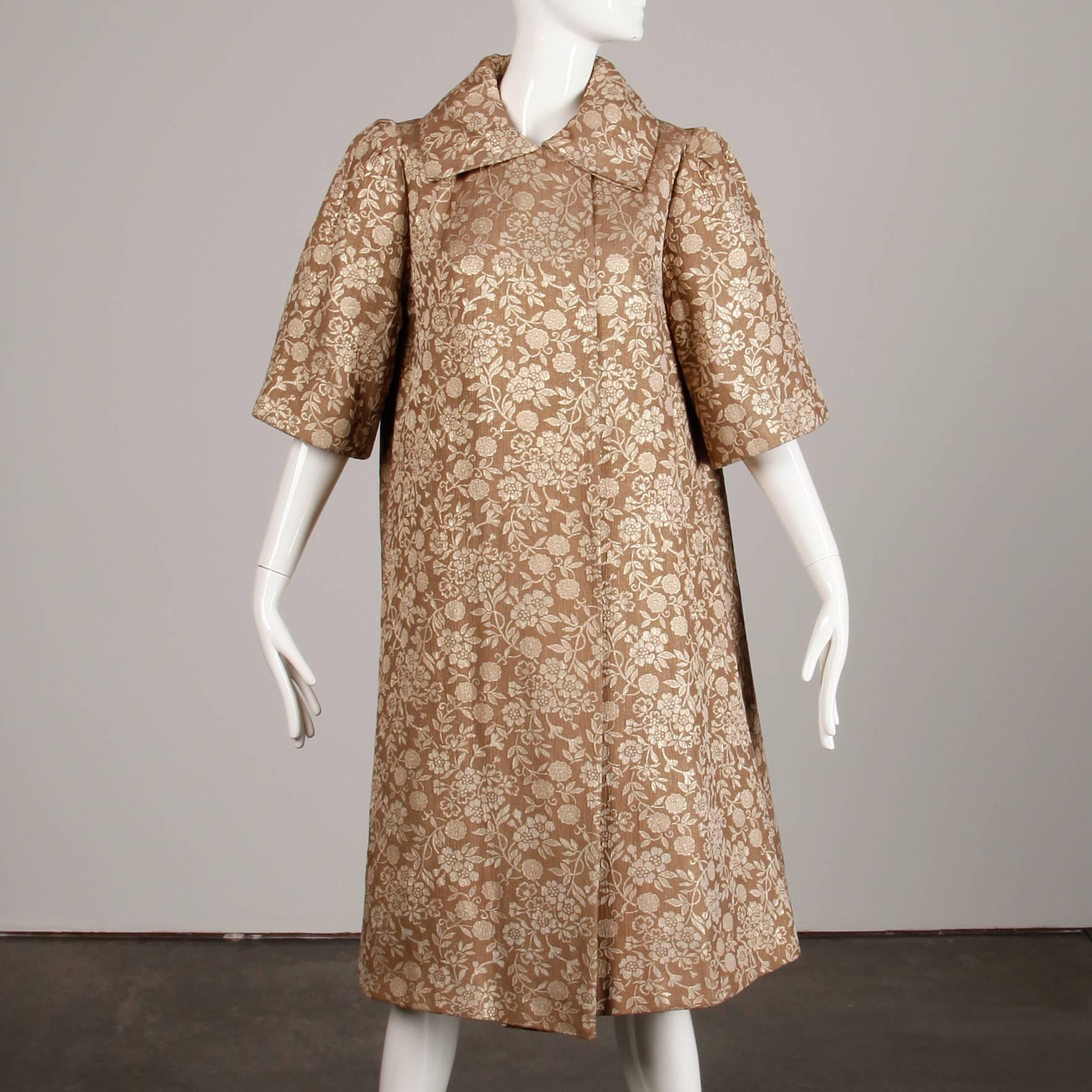 Magnifique manteau vintage des années 1960 en brocart de soie métallisé or et tan avec manches 3/4. Le tissu et la construction sont d'une qualité exceptionnelle et sont encore plus beaux en vrai ! Entièrement doublé, il se ferme à l'aide d'un