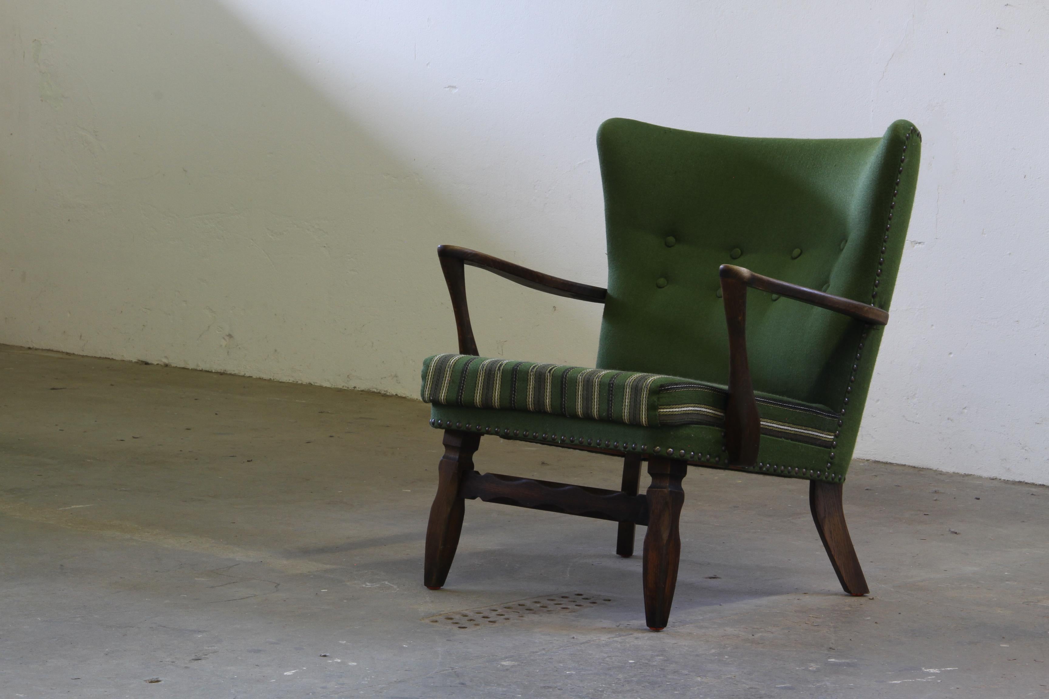 Este compacto sillón danés moderno de roble teñido de oscuro es un eco del icónico estilo de los años 60 de Viggo Boesen. Esta silla combina forma y funcionalidad con su modesto tamaño, respaldo alto y baja altura del asiento, realzada por
