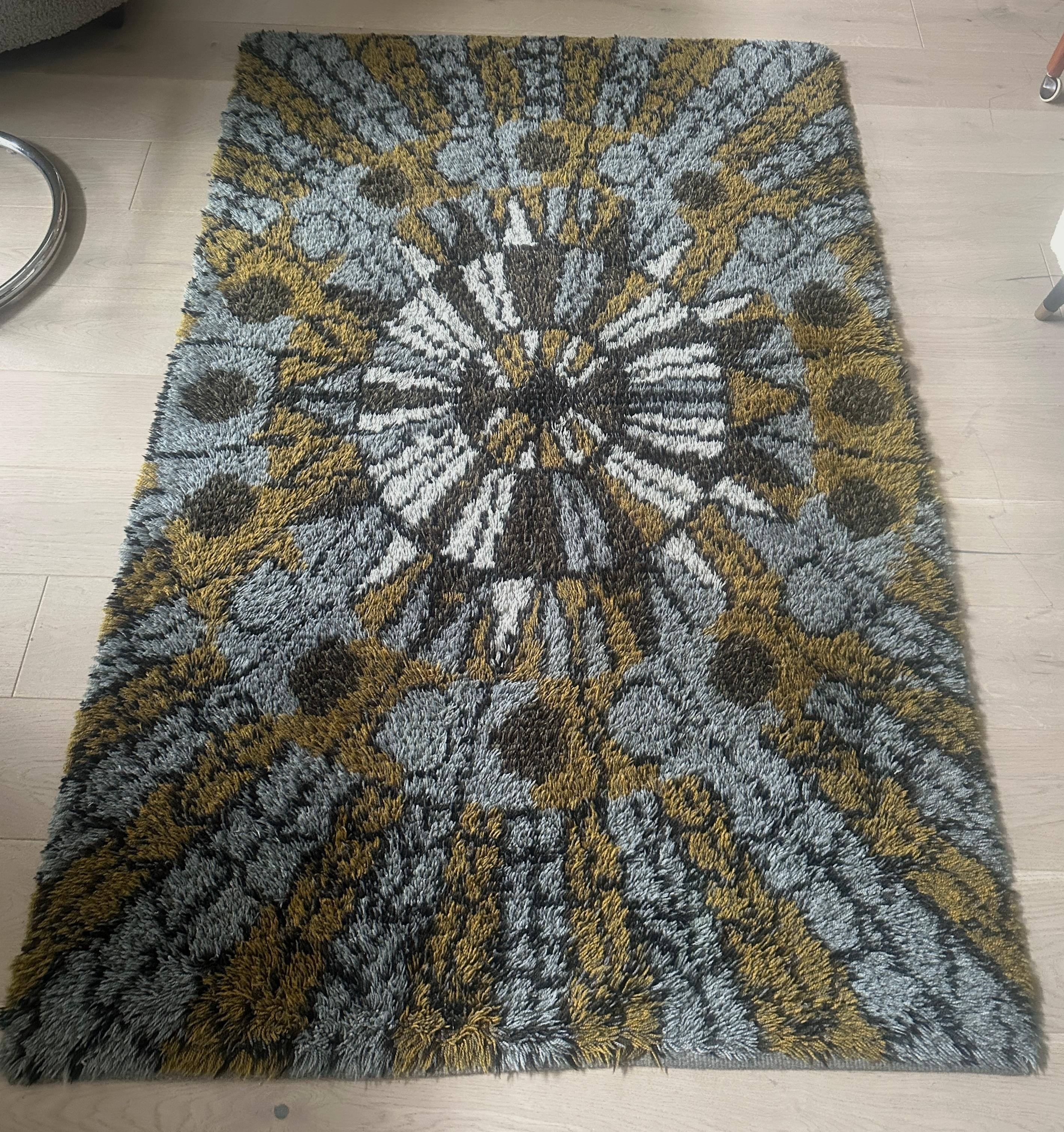 This is a vintage Scandinavian Rya rug from the 1960s, featuring a distinctive long, shaggy pile made from knotted wool. Rya rugs have a rich history, originally serving as thick bed covers for sailors in the 15th century before evolving into