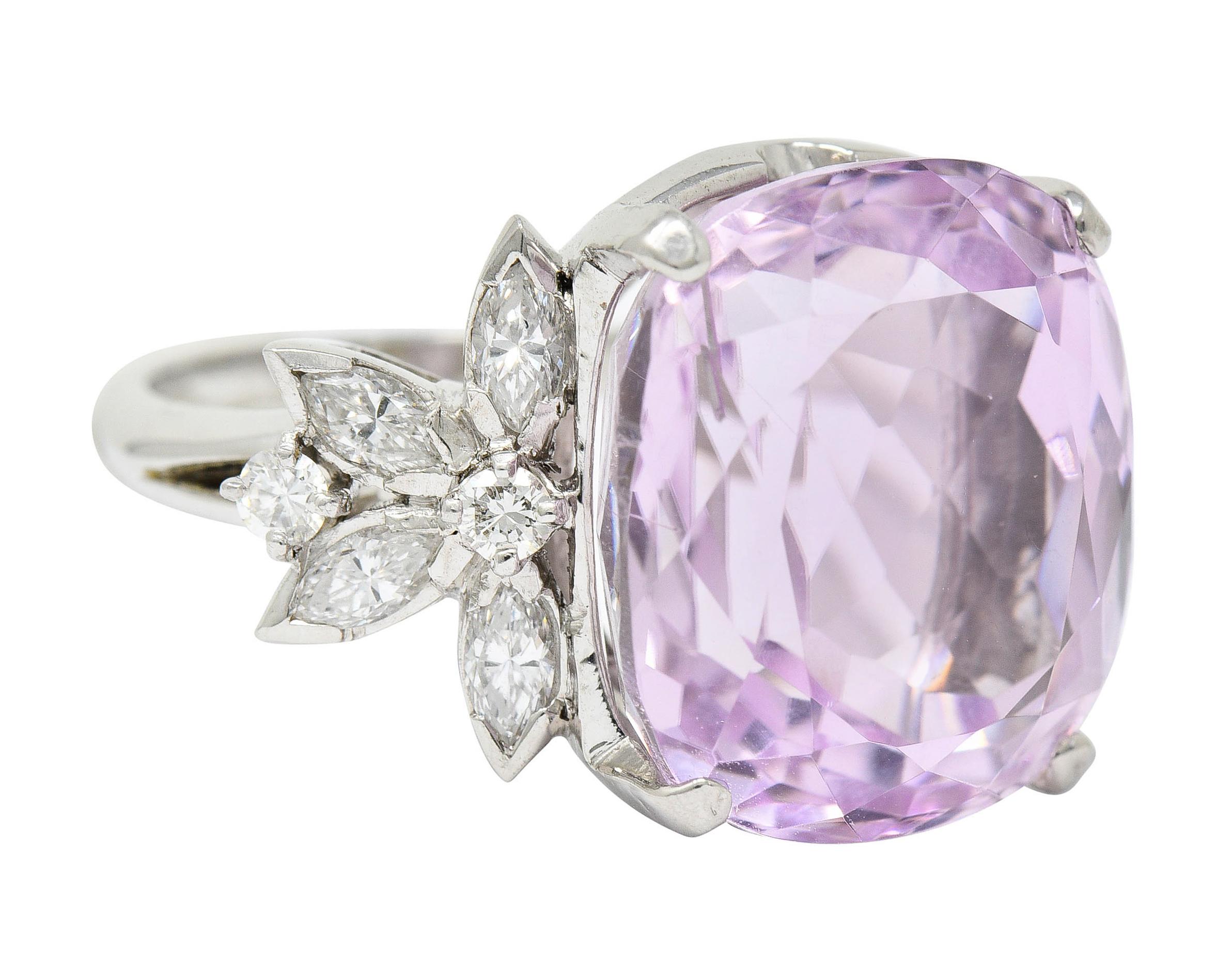Centering a basket set mixed cushion cut kunzite measuring approximately 16.5 x 15.0 mm

Transparent with stunning medium light lavender pink color

Flanked by stylized floral shoulders comprised of marquise and round brilliant cut