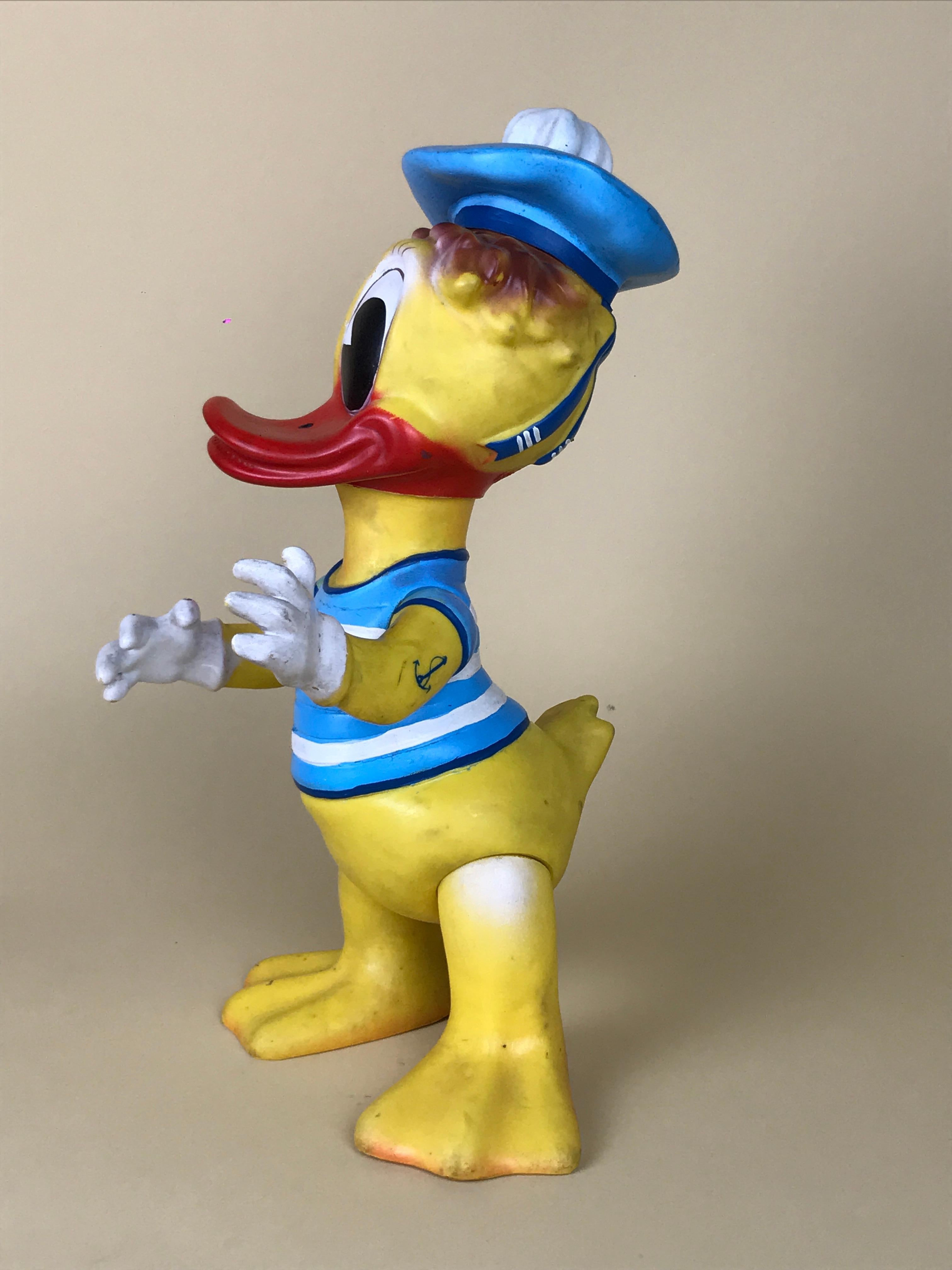 Vintage original Disney Donald Duck sailor rubber squeak toy made in Romania by Aradeanca in the 1960s.

Donald Duck sports two tattoos an anchor on the left forearm and a heart with arrow on the right forearm.

Marked with Aradeanca teddy bear