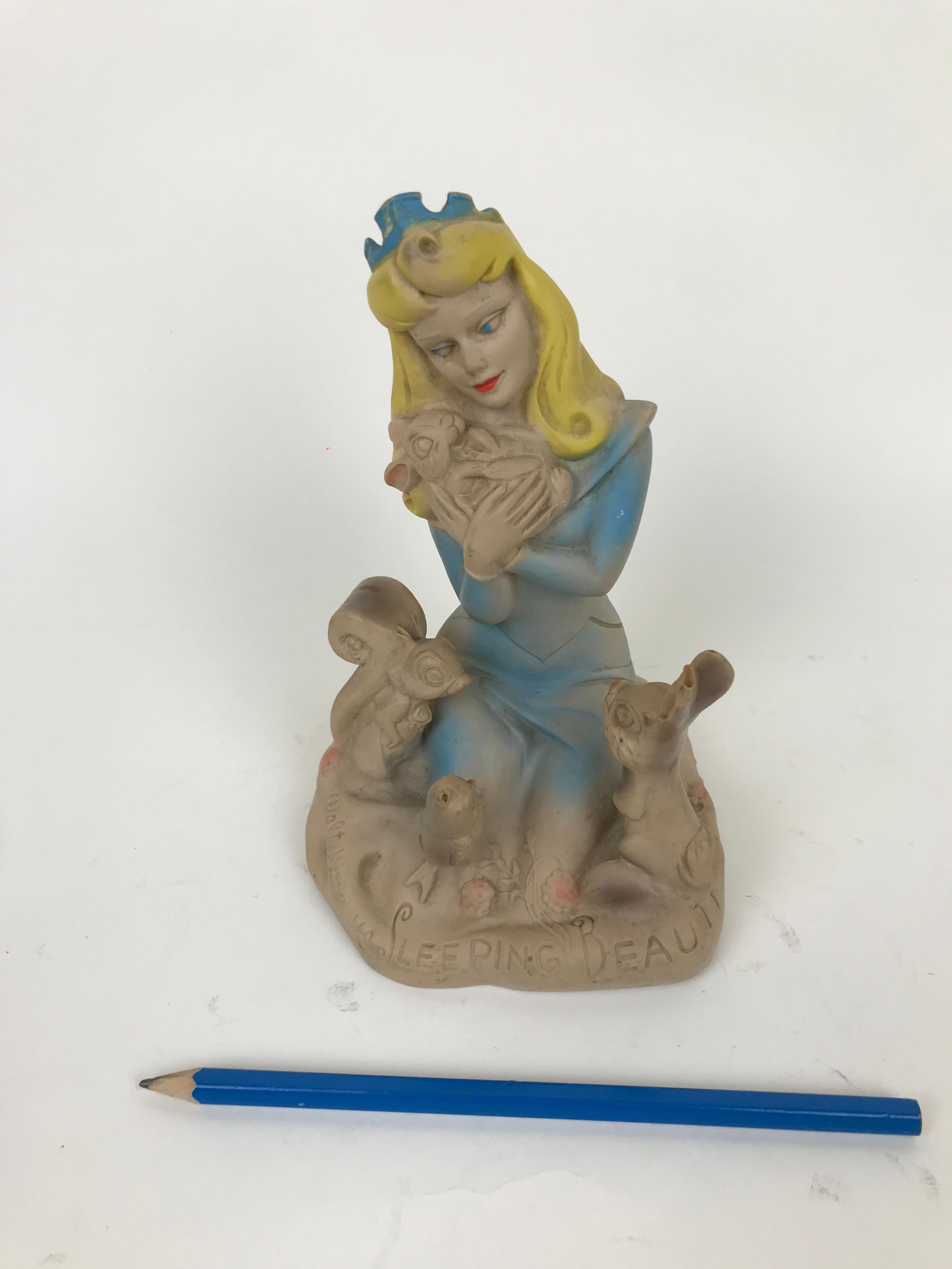 Vintage sleeping beauty squeak rubber toy made in England in the 1960s by Dell Squeak Toy.

The rubber toy represents Princess Aurora in her blue gawn sitting on a rock surrounded by a squirrel, a owl and a rabbit, while she is holding a small