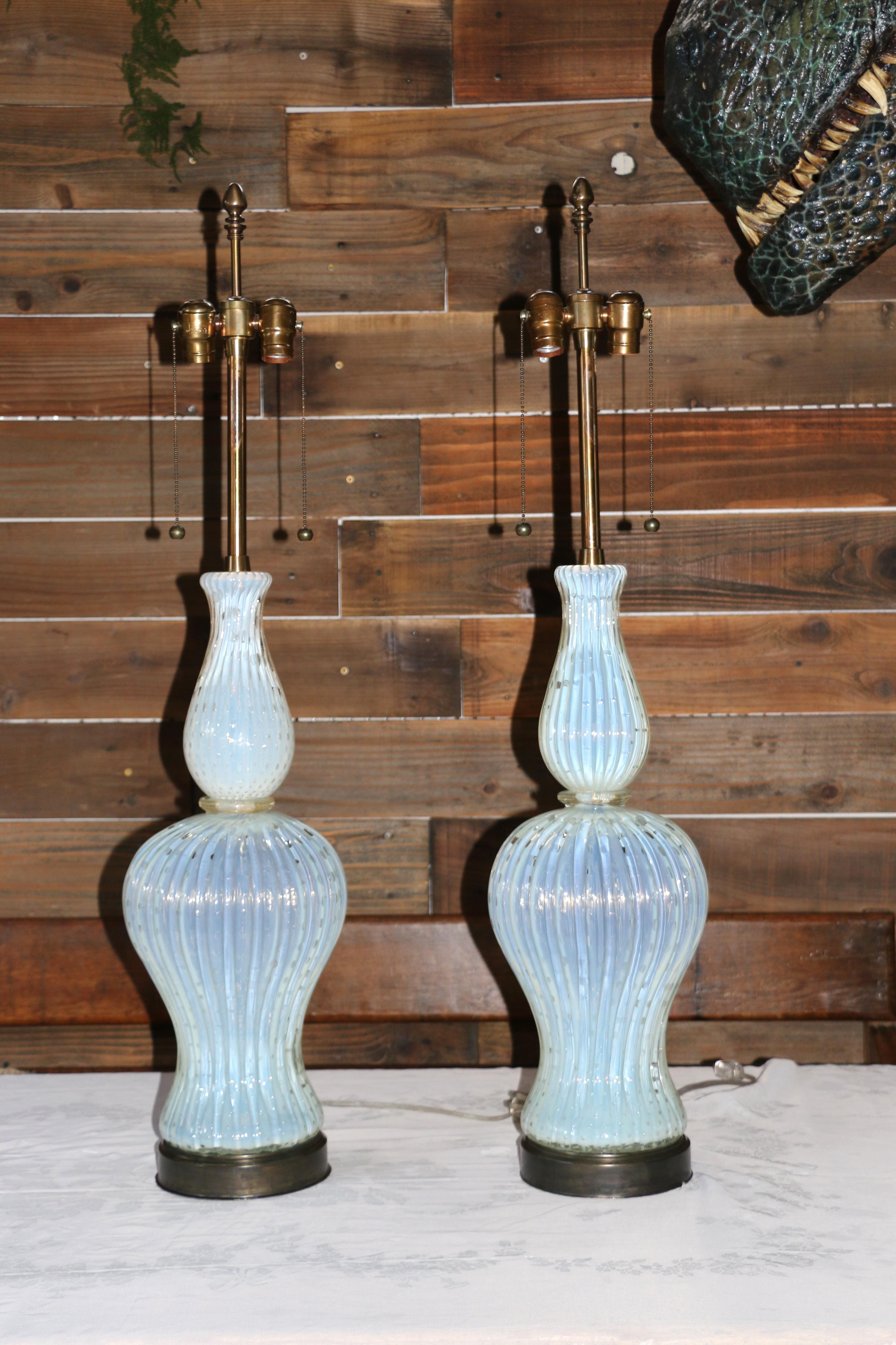 Voici cette superbe paire de lampes de table vintage en verre de Murano, datant des années 1960. Ces lampes incarnent les styles Mid-Century Modern ou Art Deco, et l'art du verre de Murano, célèbre pour sa qualité soufflée à la main, mettant en