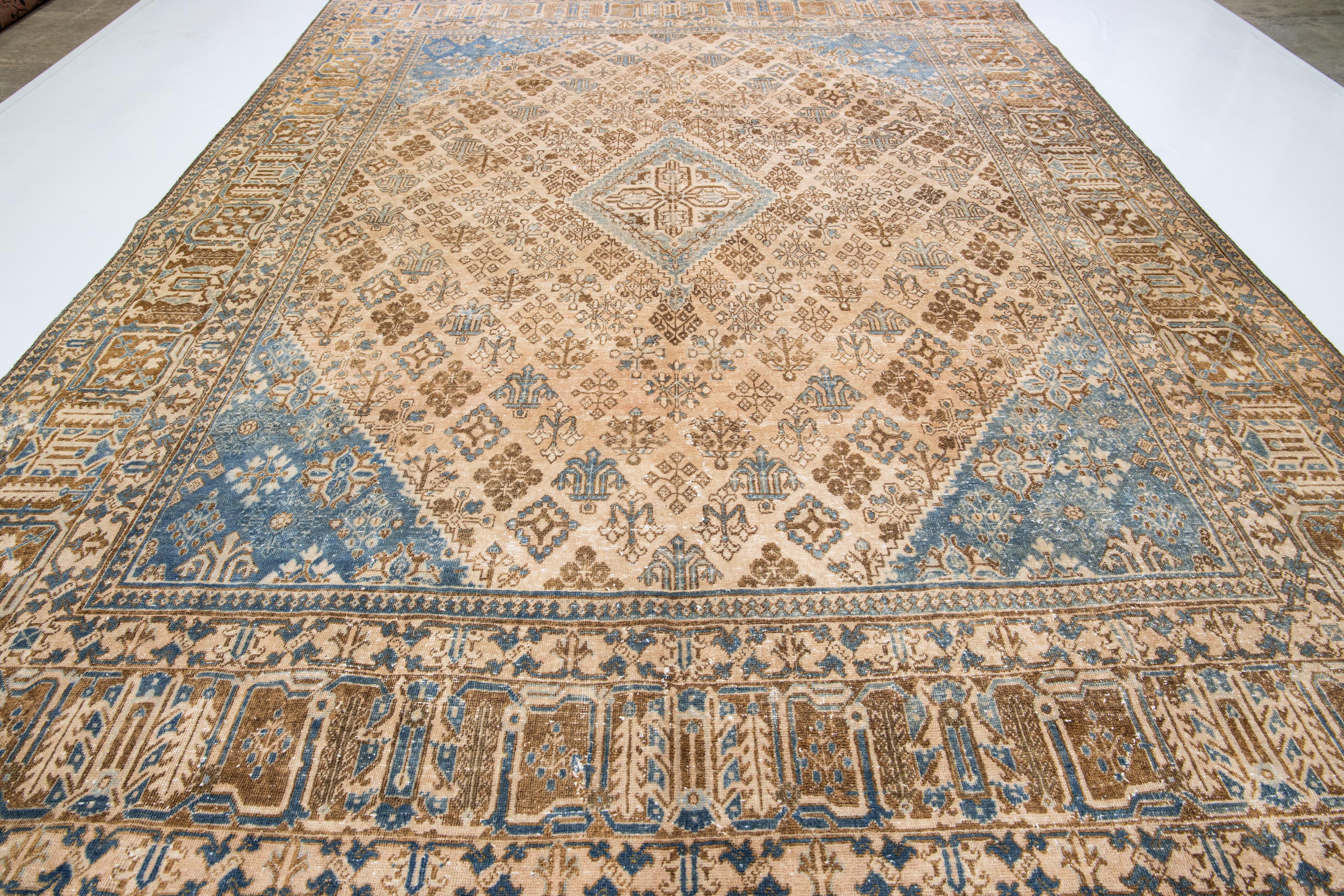 Preciosa alfombra persa vintage de lana anudada a mano con campo beige. Esta pieza tiene toques azules y marrones en un diseño de medallón integral.

Esta alfombra mide 10'5