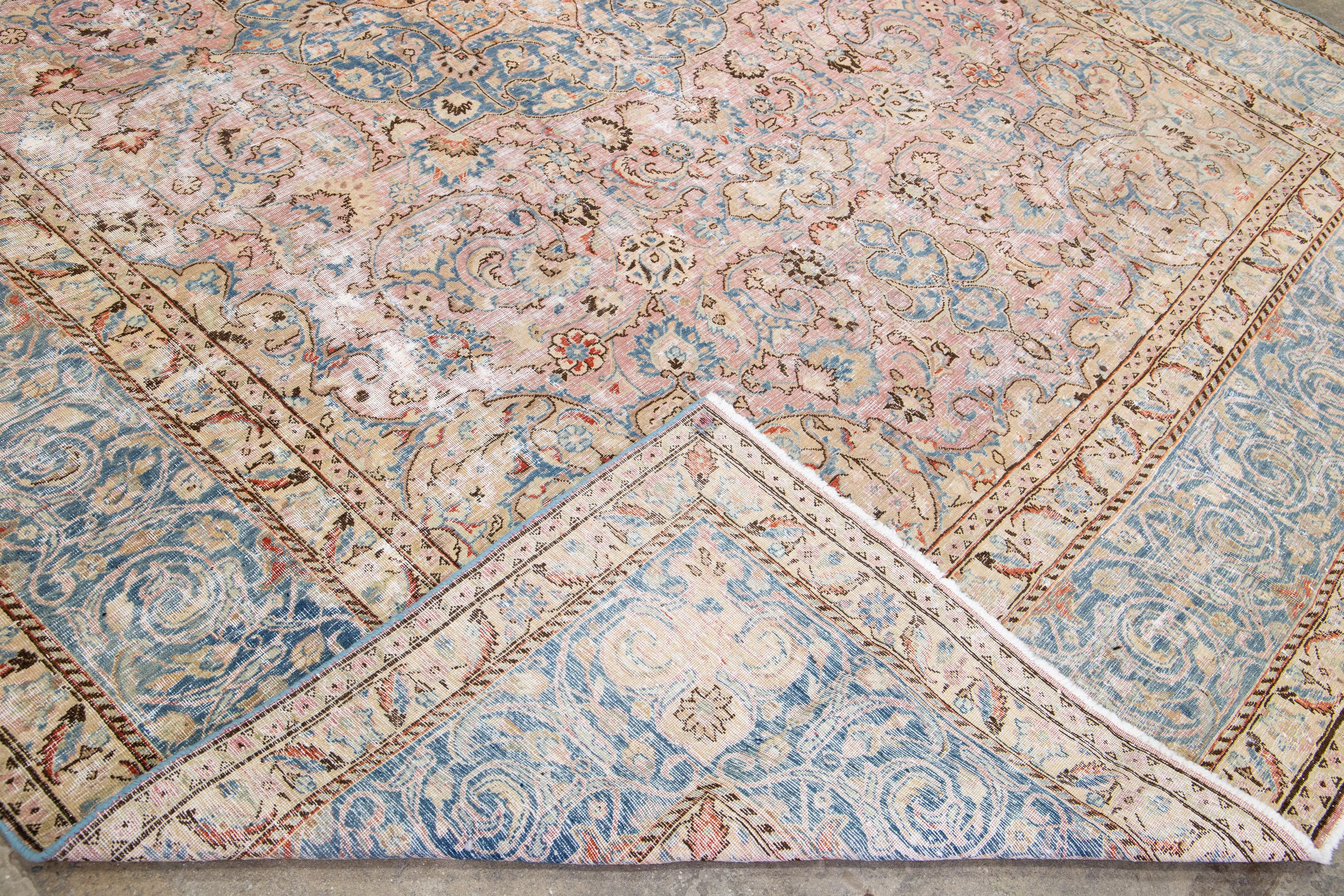 Schöner persischer handgeknüpfter Wollteppich im Vintage-Stil mit einem rosafarbenen Feld. Dieses Stück hat einen blauen Rahmen und mehrfarbige Akzente in einem geometrischen, floralen Design.

Dieser Teppich misst: 9'11
