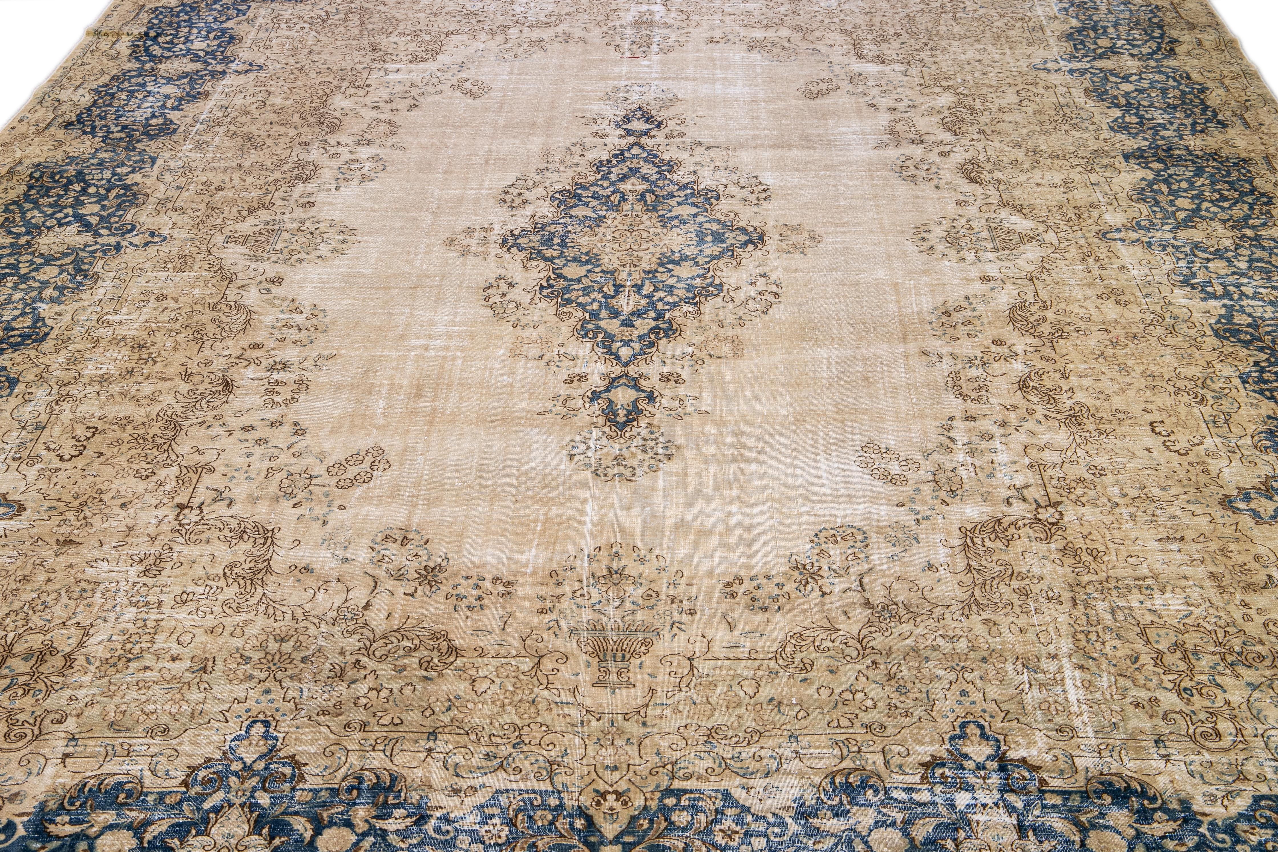 Beautiful vintage Persian distressed hand-knotted wool rug with a beige field. This piece has a blue frame with brown accents in a medallion design.

This rug measures: 12'7 x 17'5.

Our rugs are professional cleaning before shipping.