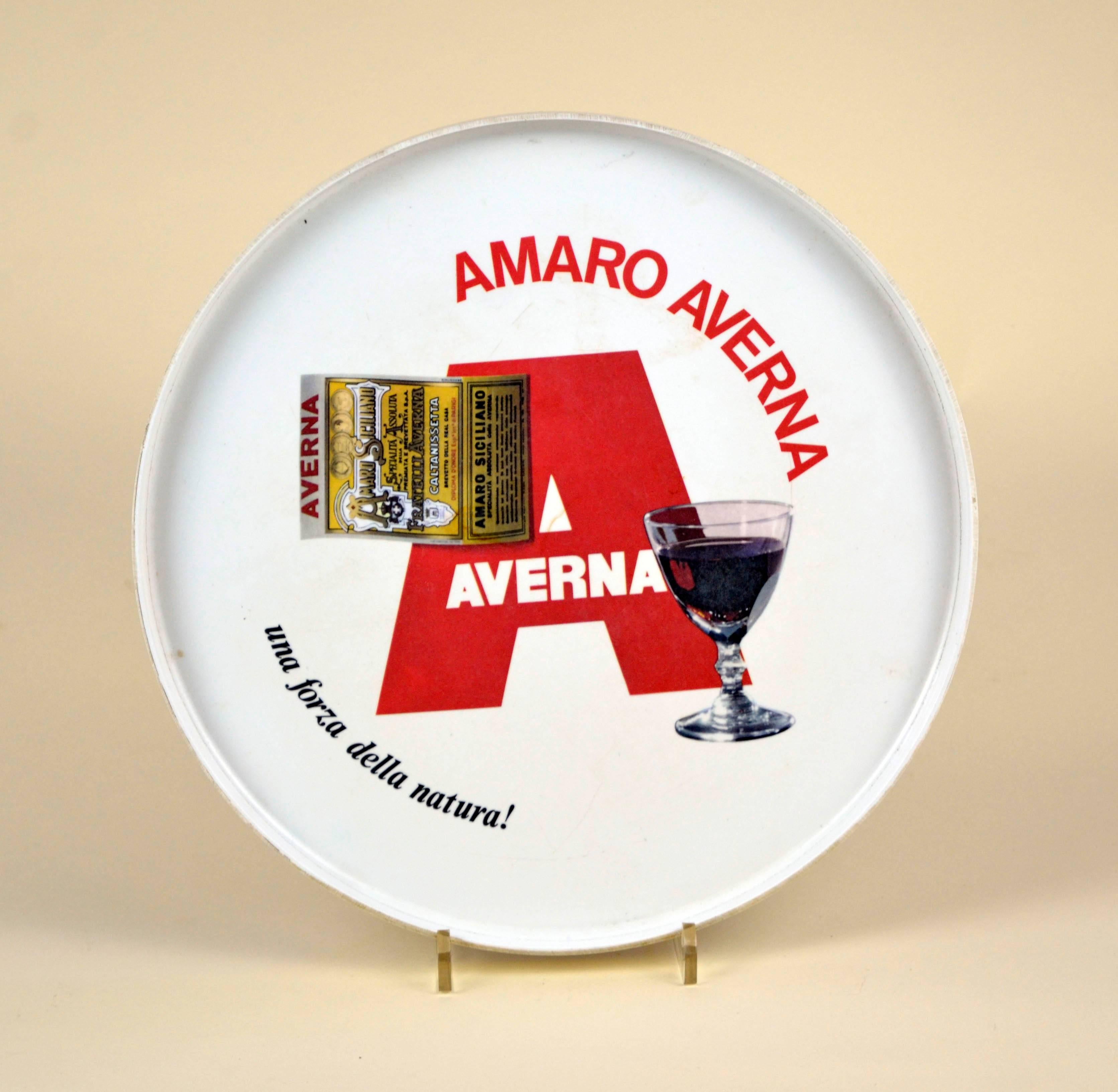 Vintage white plastic round bar tray made in Italy by Mabel for Amaro Averna.

The tray shows a large red latter A initial of Averna, the liqueur label and an image of a glass of Amaro Averna with the slogan 