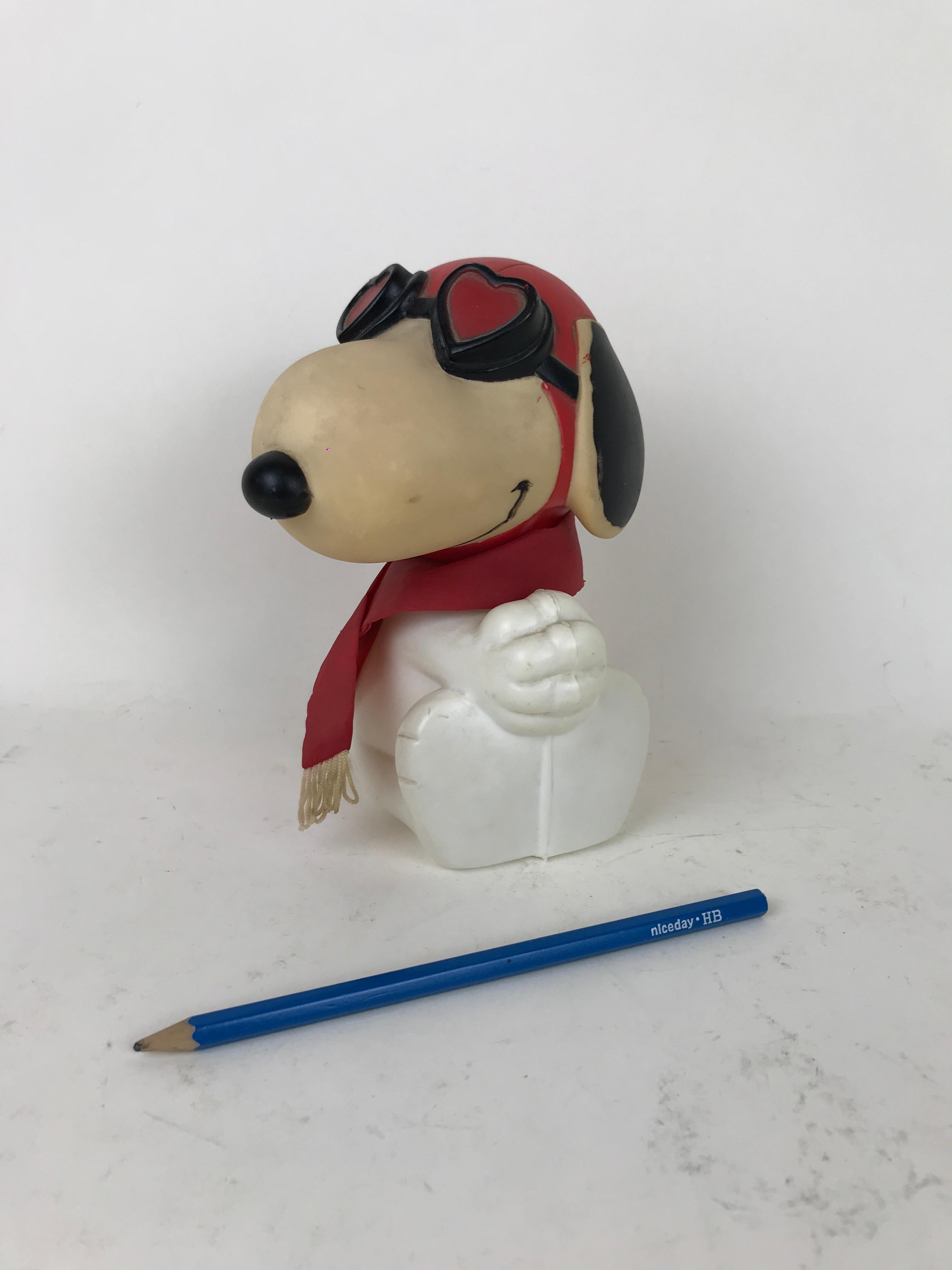 Vintage plastic bottle in the shape of Snoopy wearing a red scarf and heart shaped googles made in US in the 1960s.

The bottle can be opened and used and is composed by thee components (head, body and scarf)

Marked on bottom: 
Snoopy ©