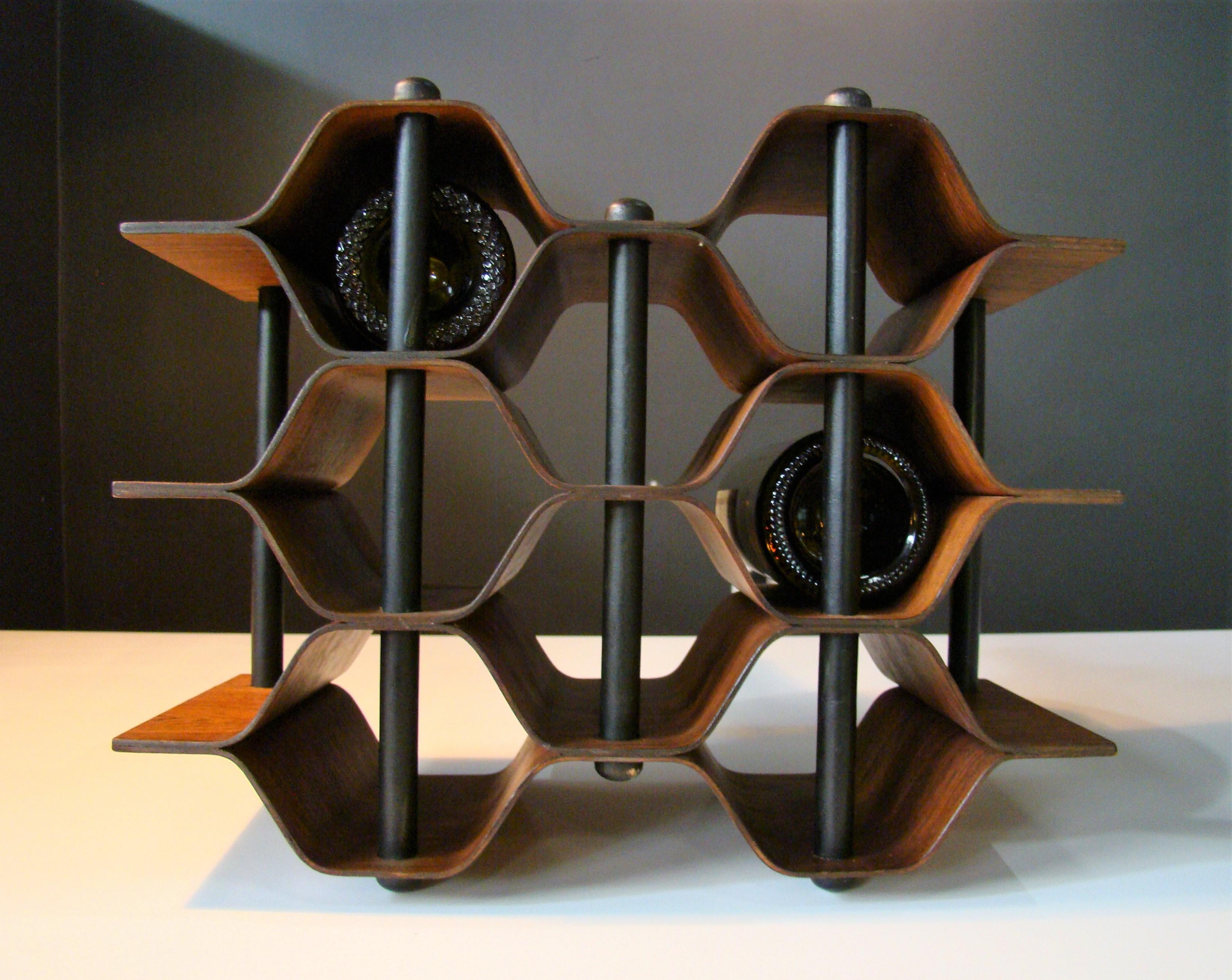 Vintage rosewood bottle holder designed by Swedish sculpture Torsten Johansson c. 1960, this 8-bottle wine rack is constructed of pressure formed, nicely figured rosewood and blackened steel supports. Beautiful and functional. A perfect addition to