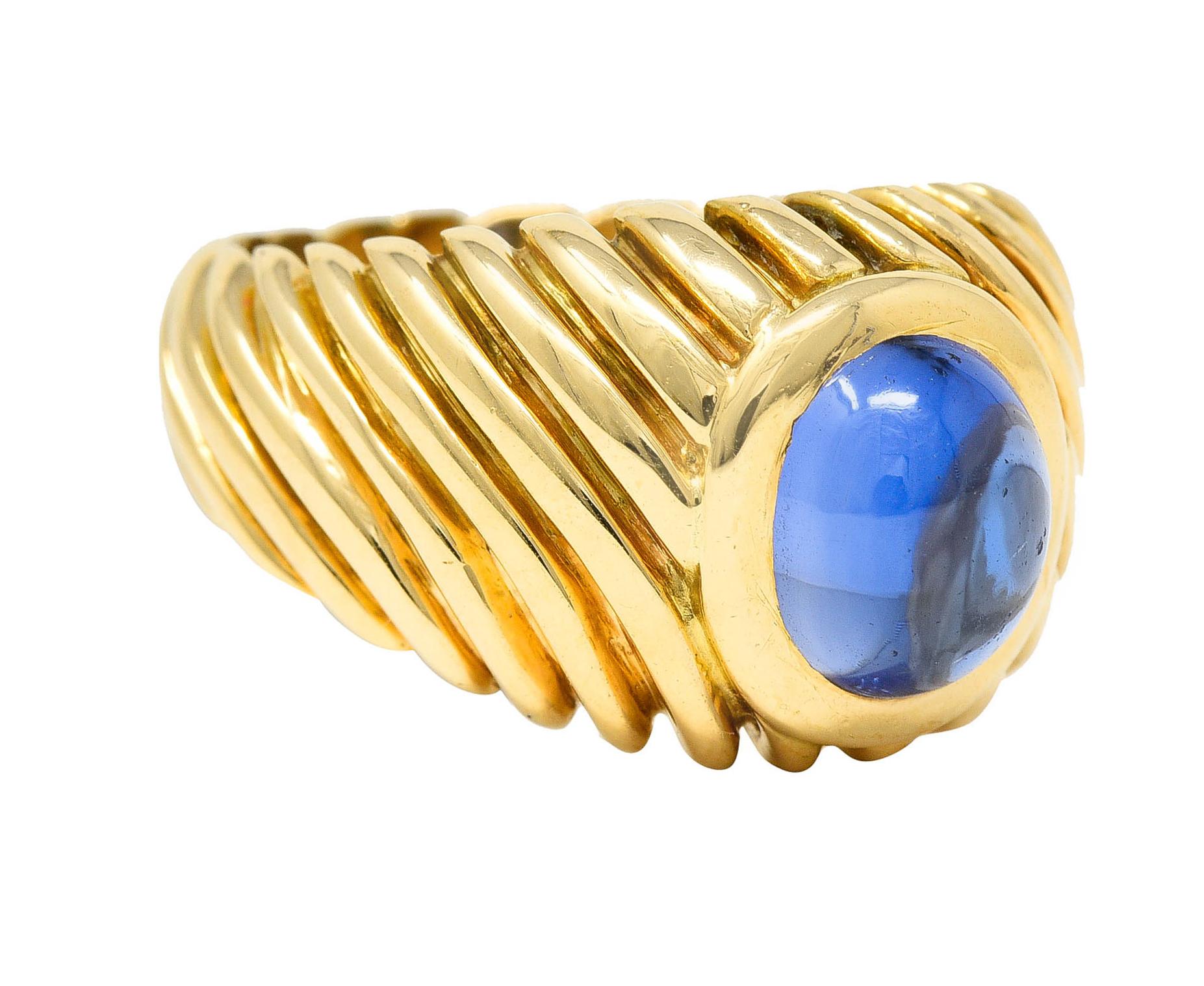 Signet style ring features an oval sapphire cabochon

Violetish blue in color while weighing approximately 2.85 carats

Bezel set in a polished gold surround of a deeply ridged mounting

Tested as 18 karat gold

Circa: 1960s

Ring Size: 5 3/4 &